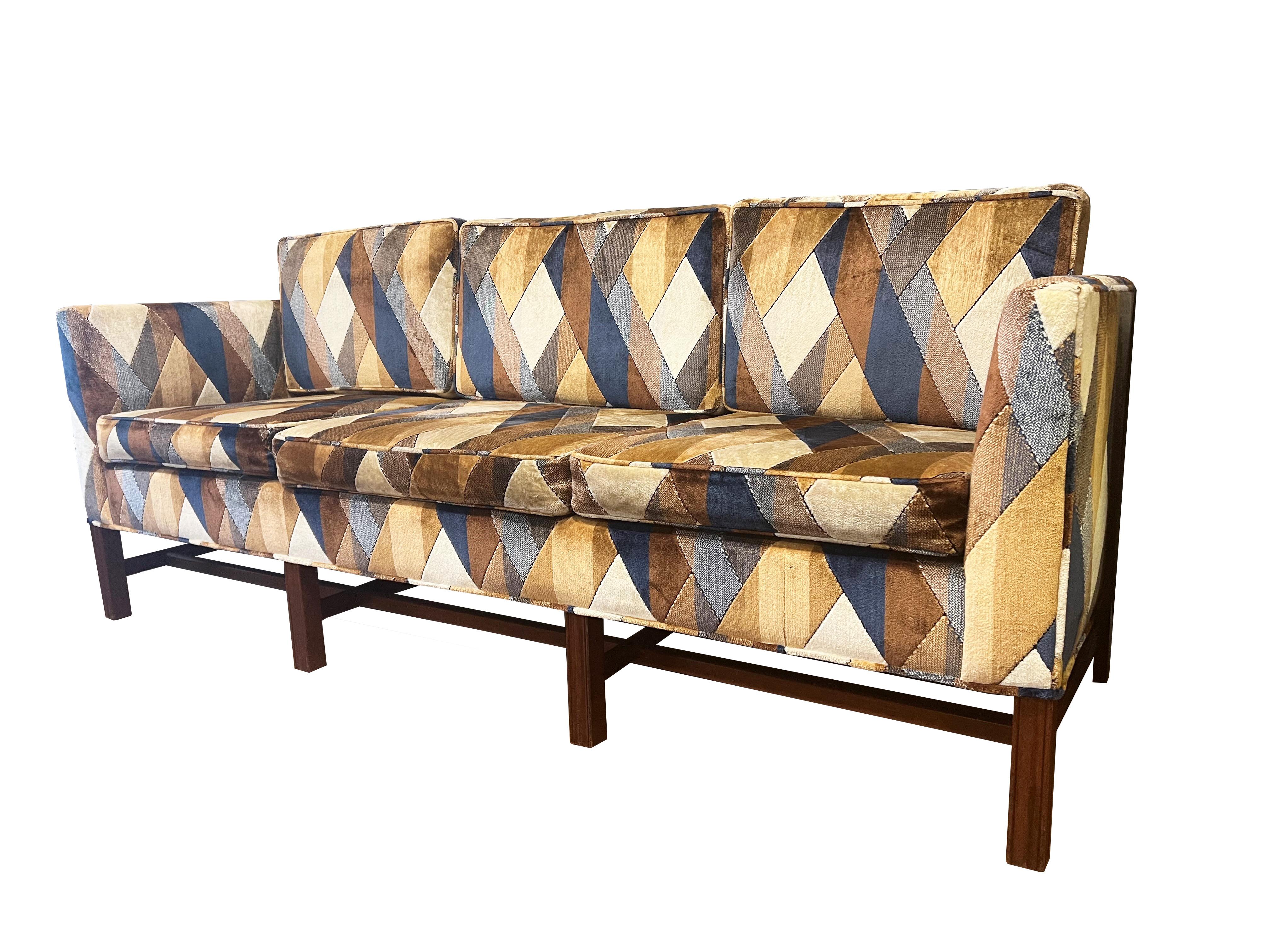 Elevate your living space with this captivating Mid-century sofa, a true embodiment of timeless style and sophistication. The luscious upholstery, adorned in a unique patterned velvet, not only adds a touch of opulence but also reflects the