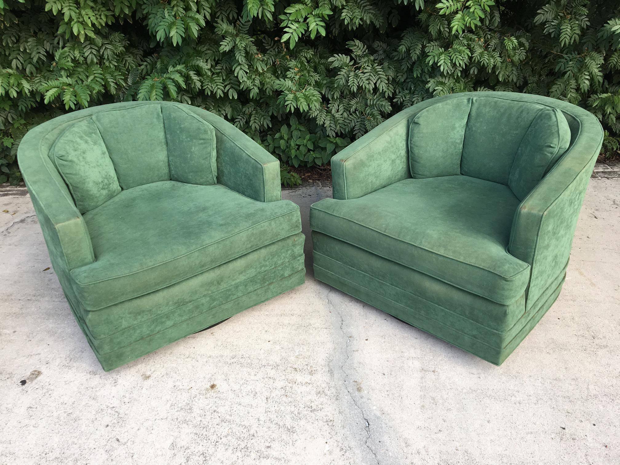 Pair of green velvet swivel club chairs ready to complete your Hollywood Regency decor. Round plinth base. By Kaylyn Inc. of High Point, NC, circa 1970s. Excellent vintage condition with minor discoloration.