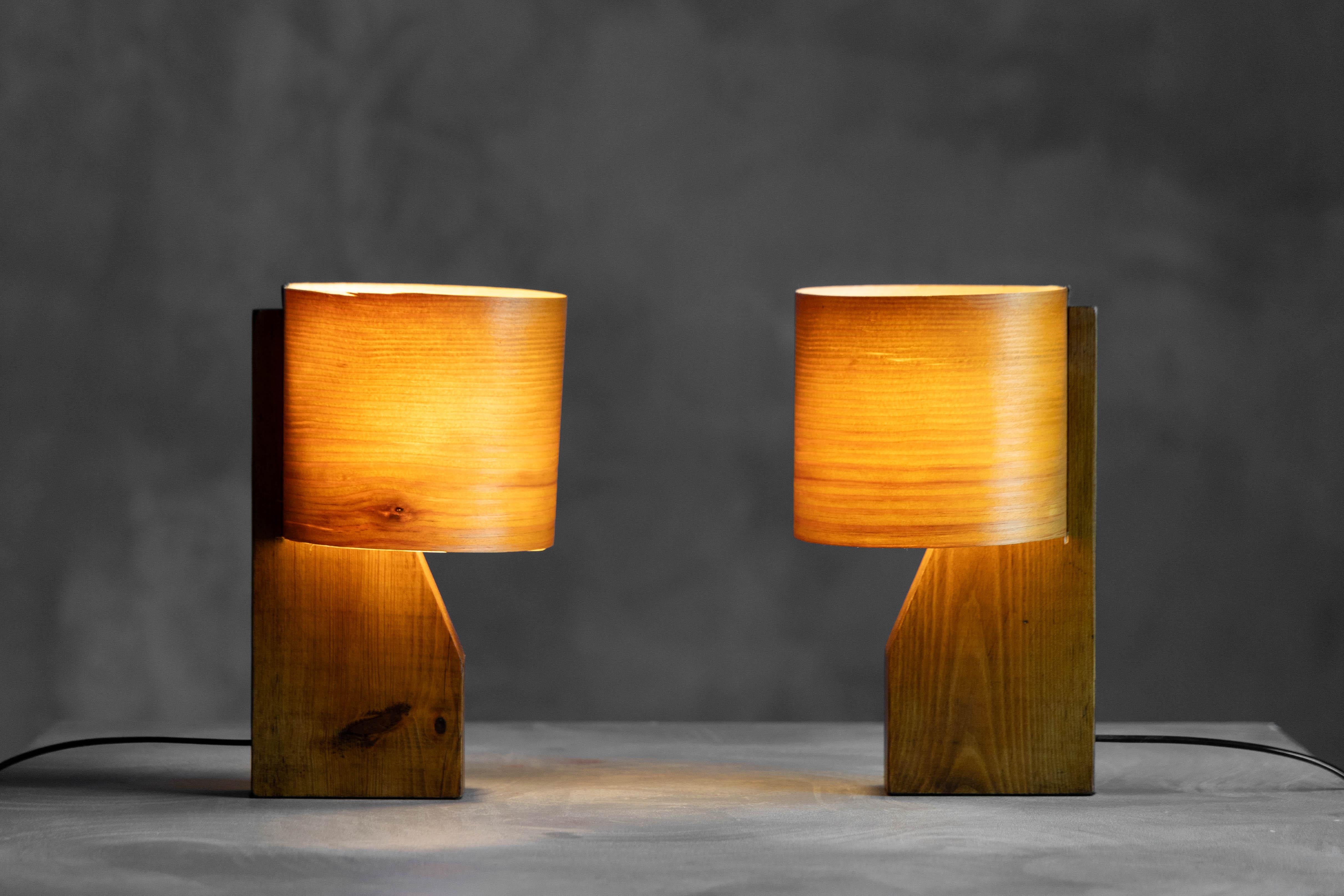 Estas lámparas de chapa de madera de mediados de siglo combinan la artesanía orgánica con un estilo moderno atemporal. Su base de madera esculpida y su fina pantalla de chapa de madera proyectan un suave resplandor natural, ideal para rincones