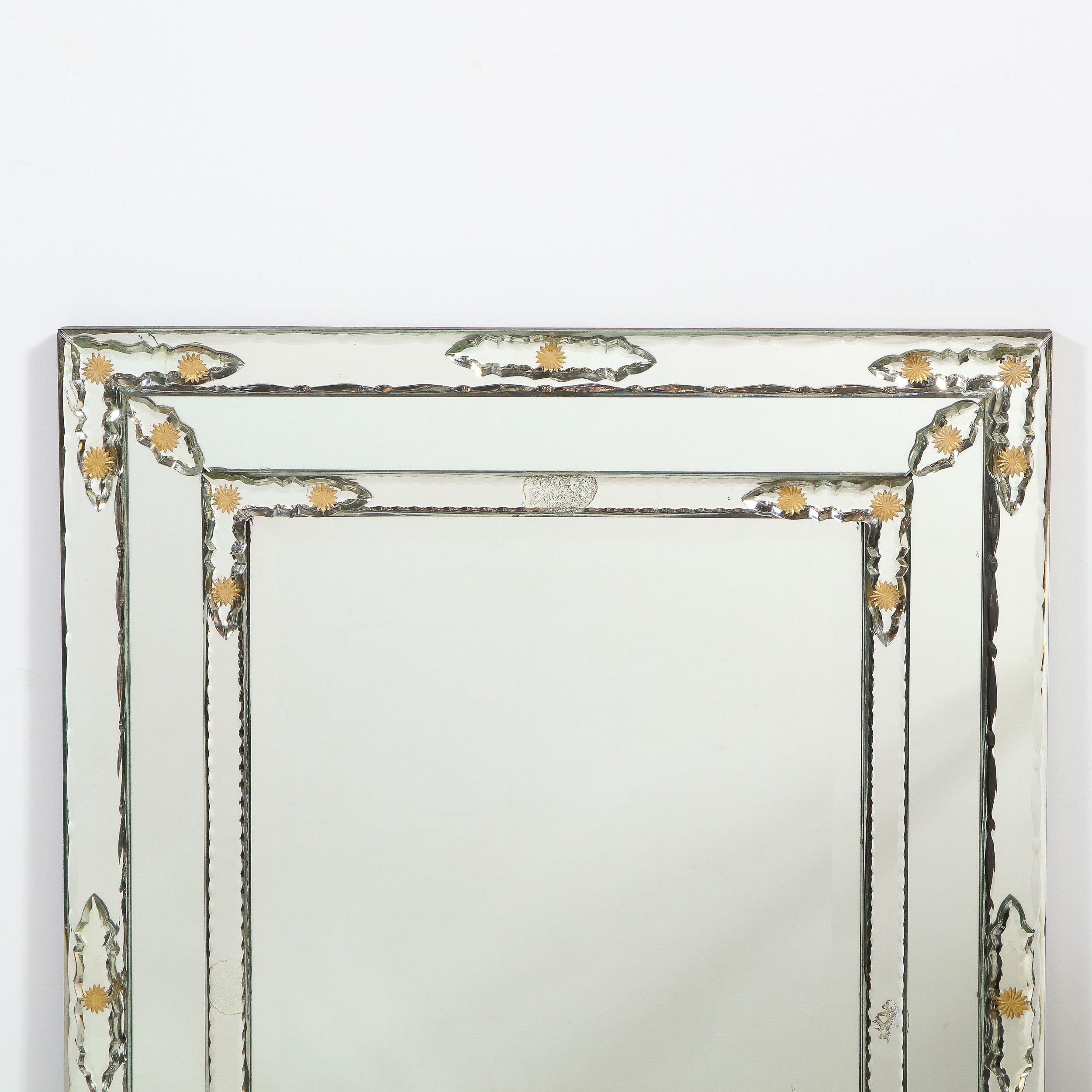 This stunning Mid-Century Modern Venetian mirror was realized in Italy, circa 1950. It features a rectangular body with concentric tiers echoing the rectangular silhouette of the piece. The border of the piece is gilded, a material which recurs in