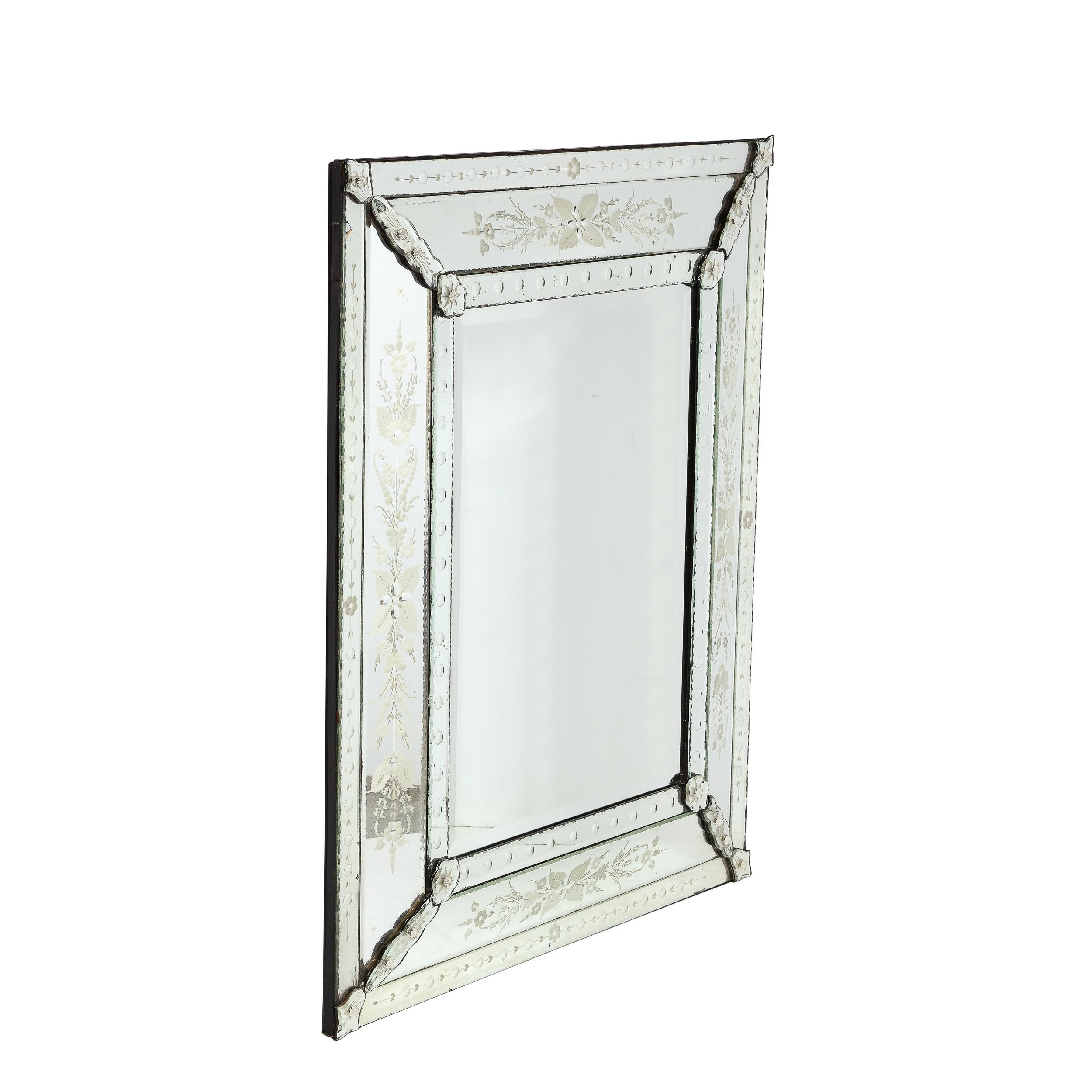 This sleek and gleaming Mid-Century Modernist Venetian Mirror Reversed Etched W/Floral Appliques and Beveled Detailing originates from Italy, Circa 1960. Features a tiered geometric composition with illustrious detailing and precise embellishments.