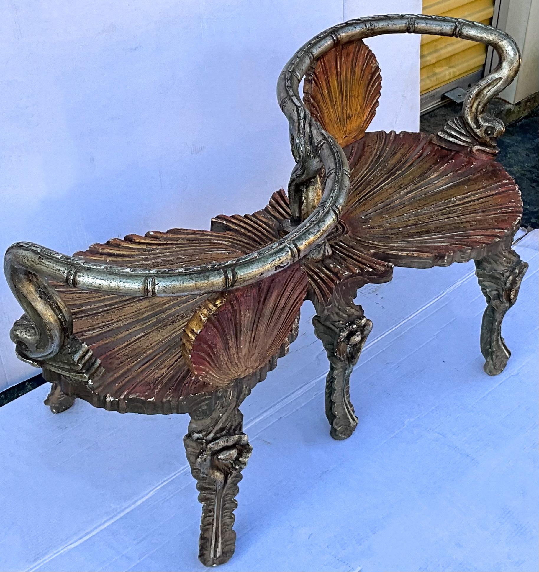 This is a show stopper! It is a midcentury Venetian silver and gold gilt shell and dolphin form tête-à-tête/ settee. It has shell form back supports along with winding dolphin rails. It has general age wear that enhances its beauty.