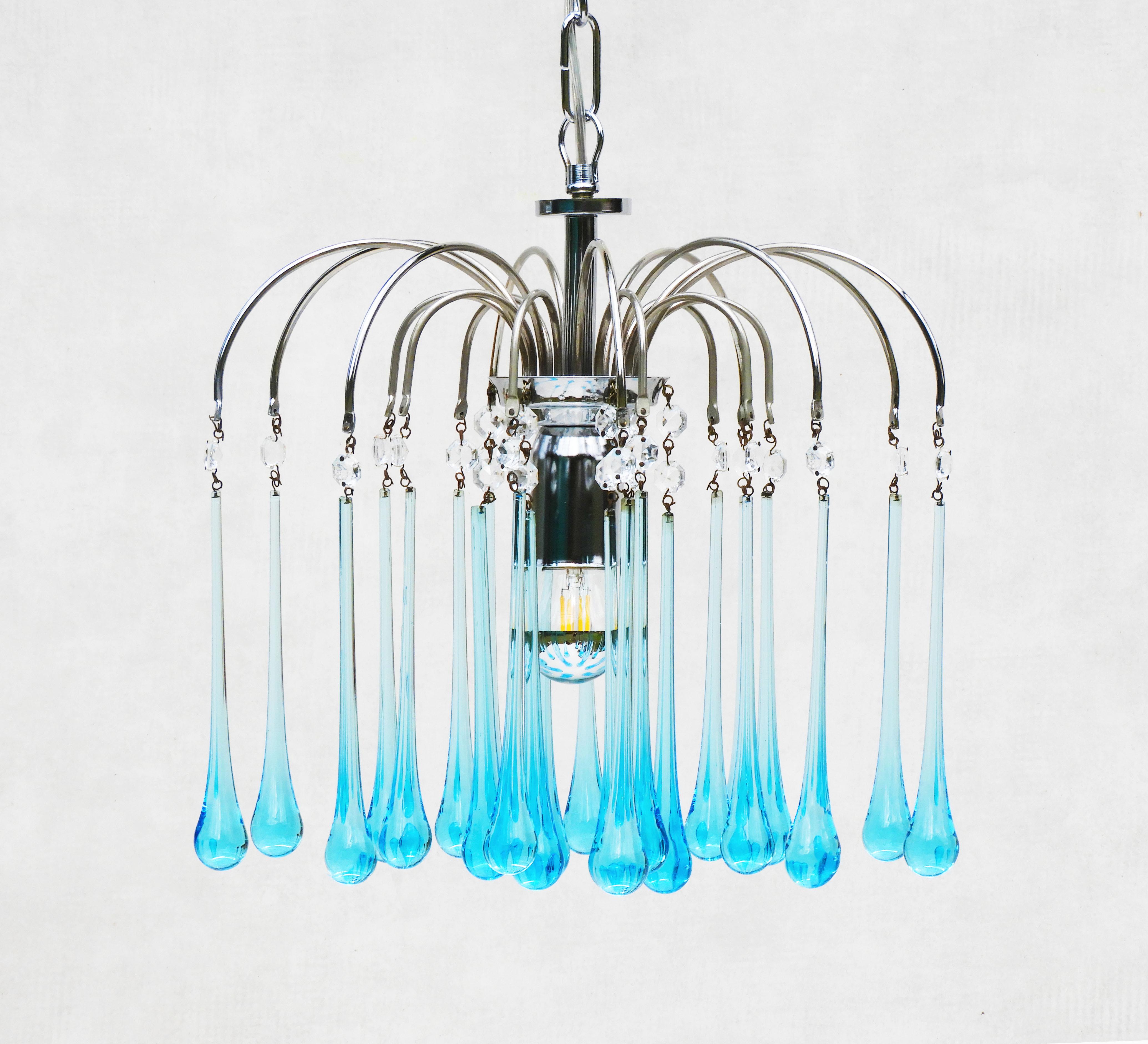 Stunning Paulo Venini Style waterfall pendant chandelier.
Beautiful Murano glass cascade pendant light, 24 blue ‘teardrop’ crystals on a three-tier chrome frame.
In great vintage condition with good patina and no losses to glass. Completely