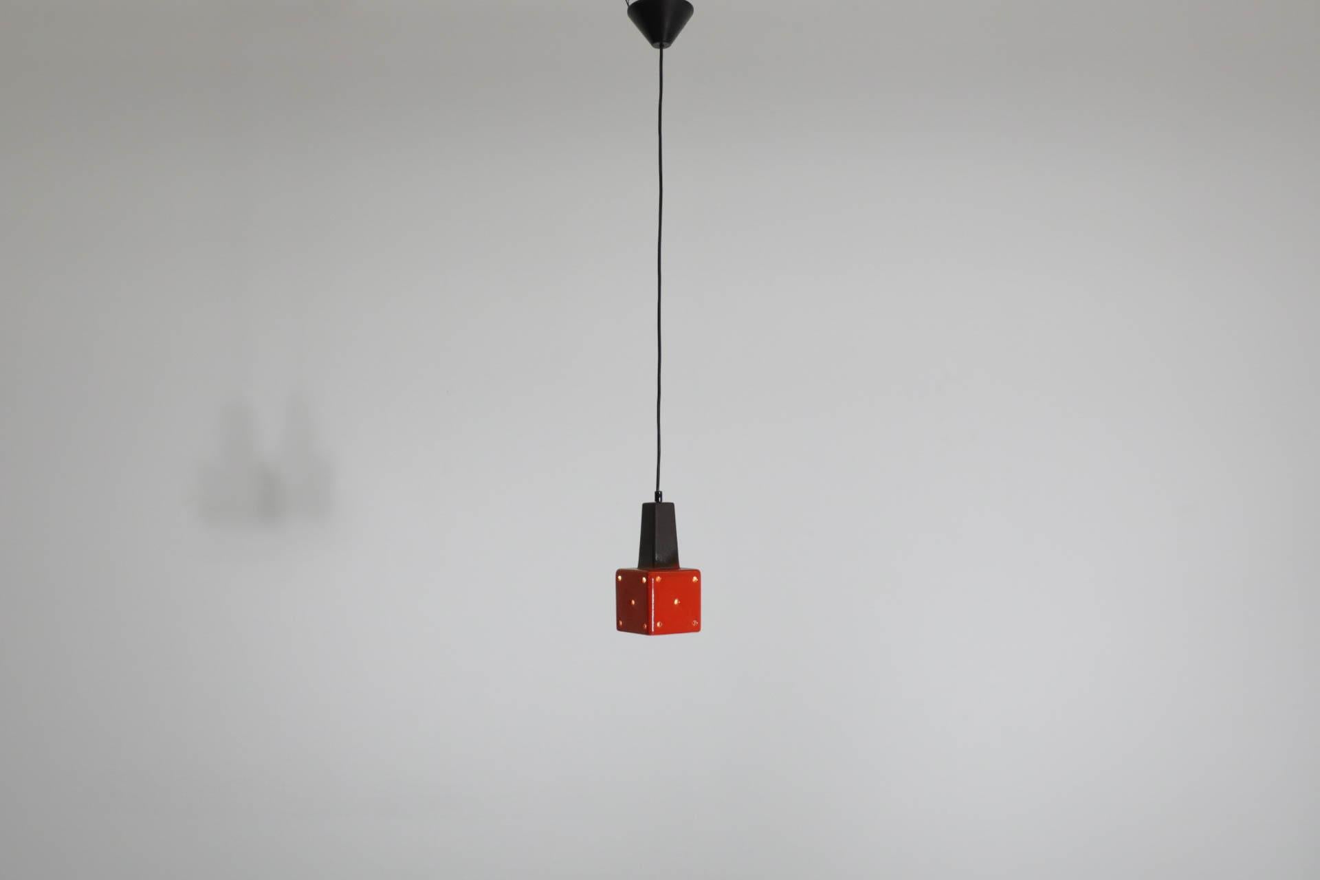 Mid-Century West-German glossy vibrant red-orange glazed ceramic pendant with contrasting matte brown stem and swiss cheese-like cutouts for ambient light. In good condition with No scratches or wear. No manufacturer stamp. Some glaze imperfection