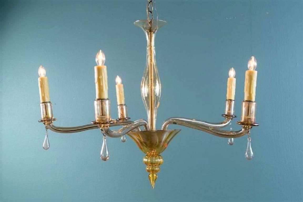 Handblown, amber colored glass chandelier from Murano, Italy, circa 1960s in the style of Venini. Handblown glass candle cups and glass drops on each of the five arms. Unusual style of arm and finial. Newly rewired for use in the USA with all UL