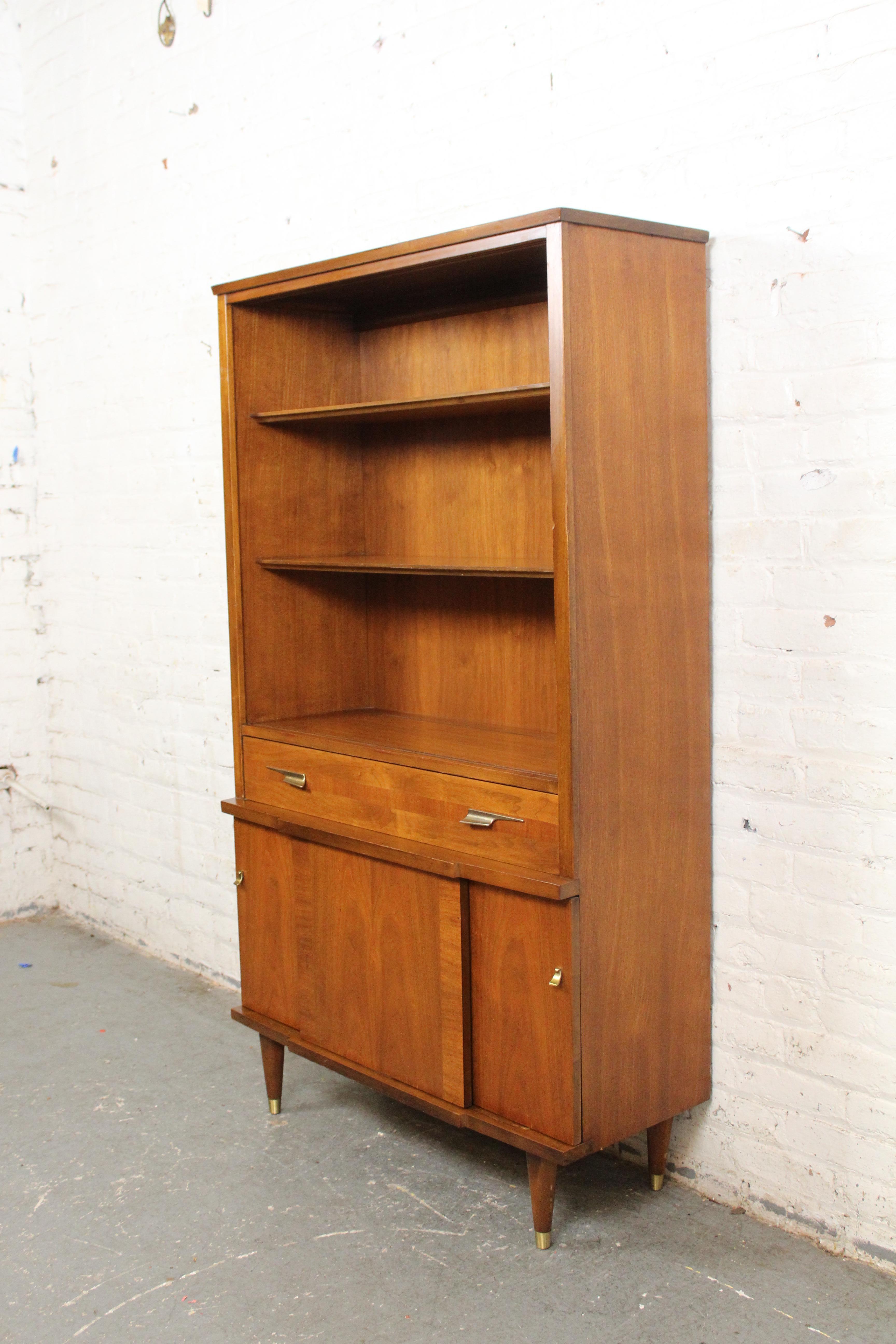 Mit diesem charmanten Bücherregal aus der Mitte des Jahrhunderts können Sie Ihre Sachen stilvoll aufbewahren. Dieses Vintage American Modern Design zeichnet sich durch eine furnierte Nussbaumkonstruktion mit attraktiven kontrastierenden