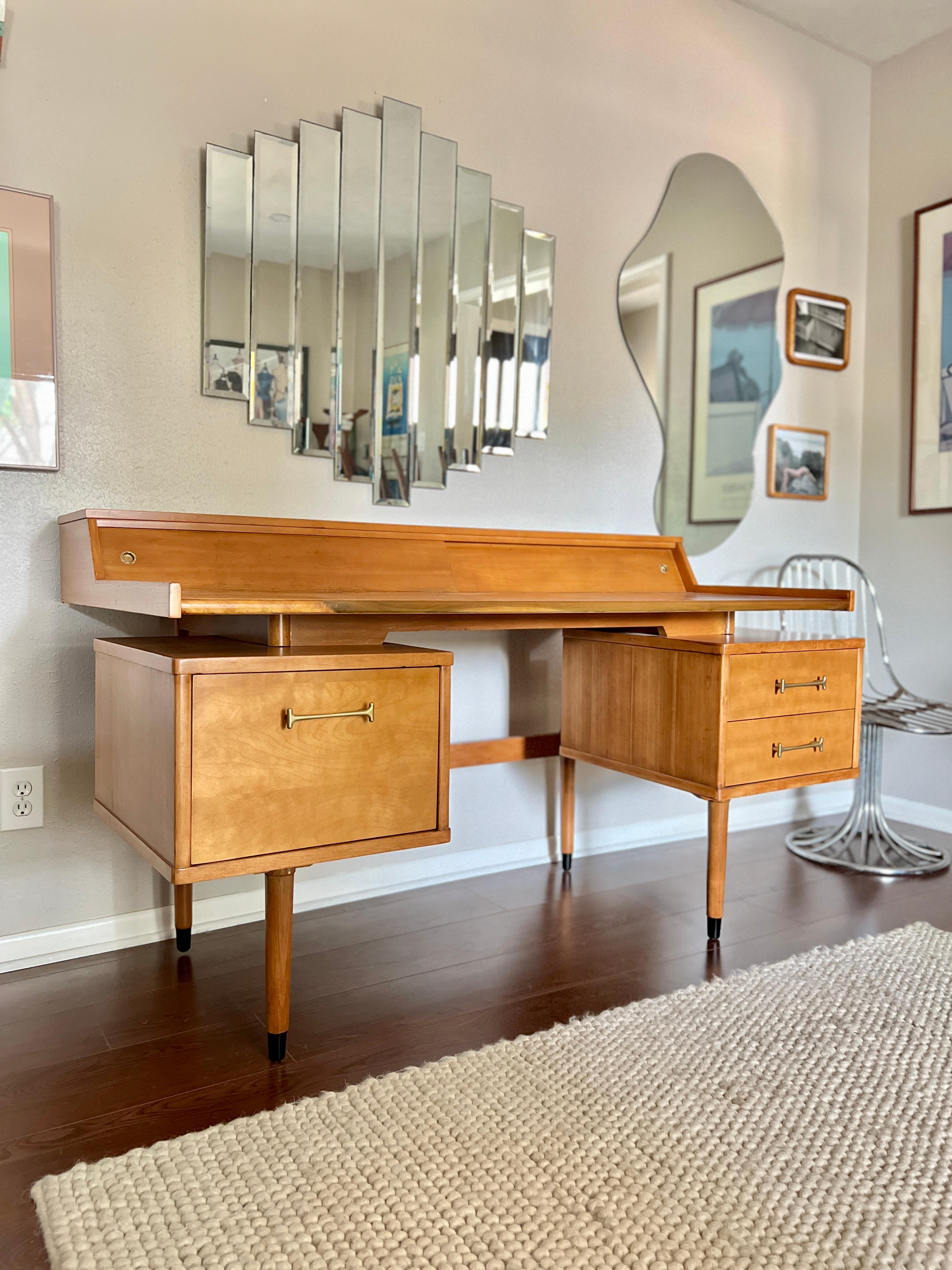 Wonderful vintage “Biscayne” floating top desk by Drexel circa 1960s. The left drawer has a file slot which can be removed if needed and on the right side has two dovetailed drawers. Top compartments have two sliding doors with compartments inside.