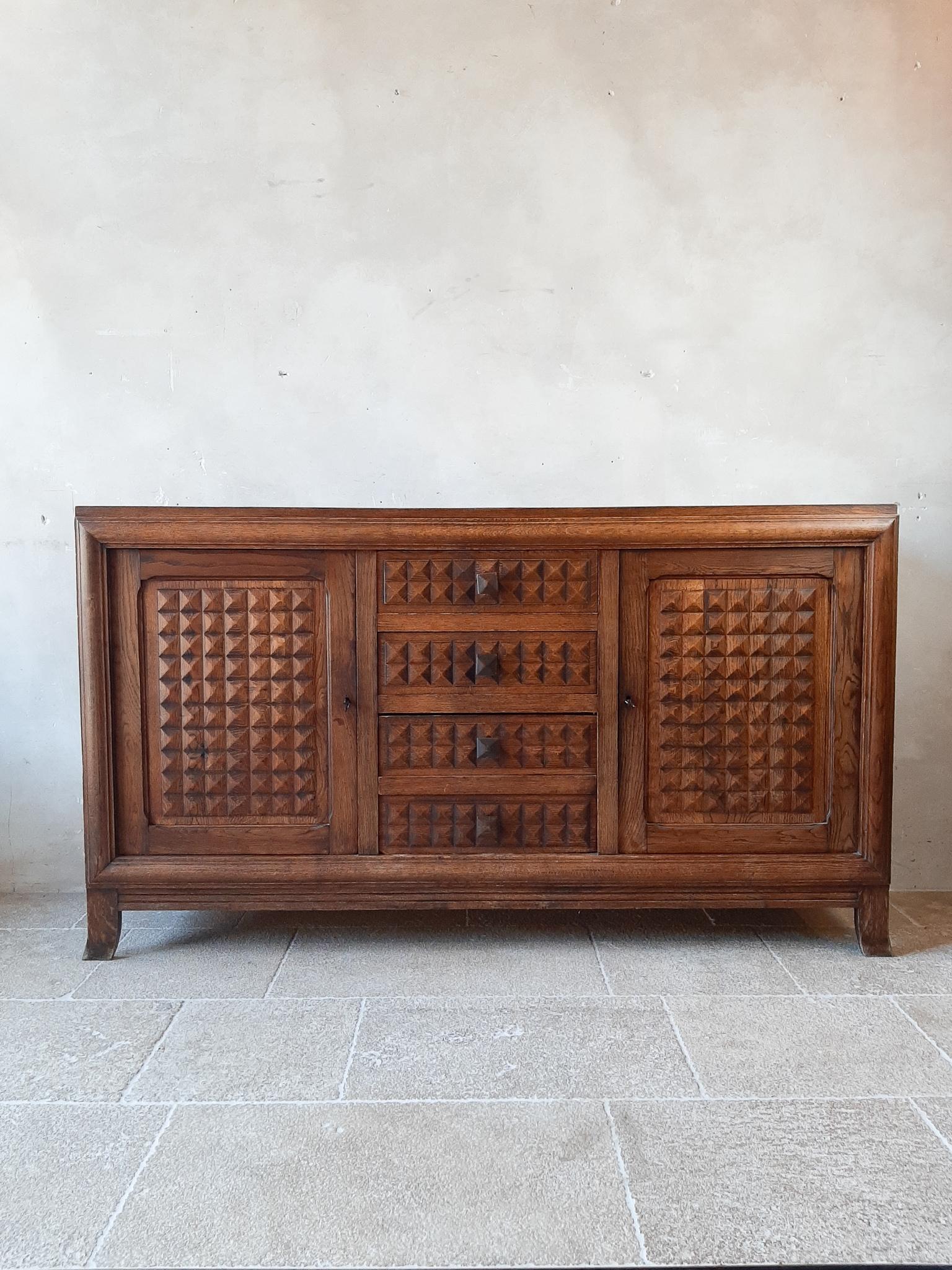 Midcentury vintage sideboard, credenza by Charles Dudouyt in brown oak with a French polish finish, 1940s-1950s. The cabinet features 2 large doors on each side, in the middle 2 drawers above a small door that looks like the bottom two drawers. The