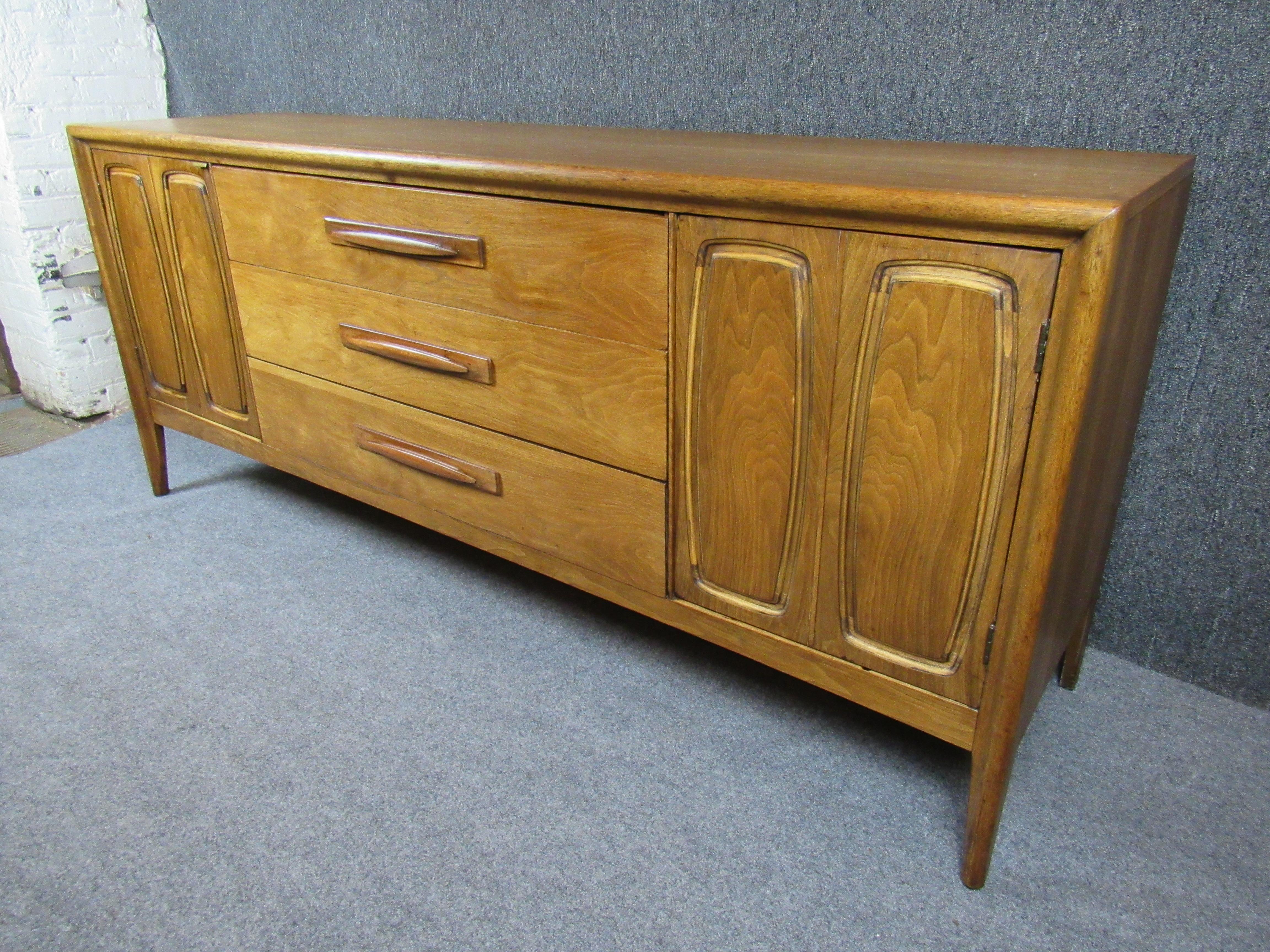Llévate a casa el auténtico diseño moderno americano de mediados de siglo con este fantástico aparador pequeño de Broyhill Premier Furniture. De su emblemática serie 