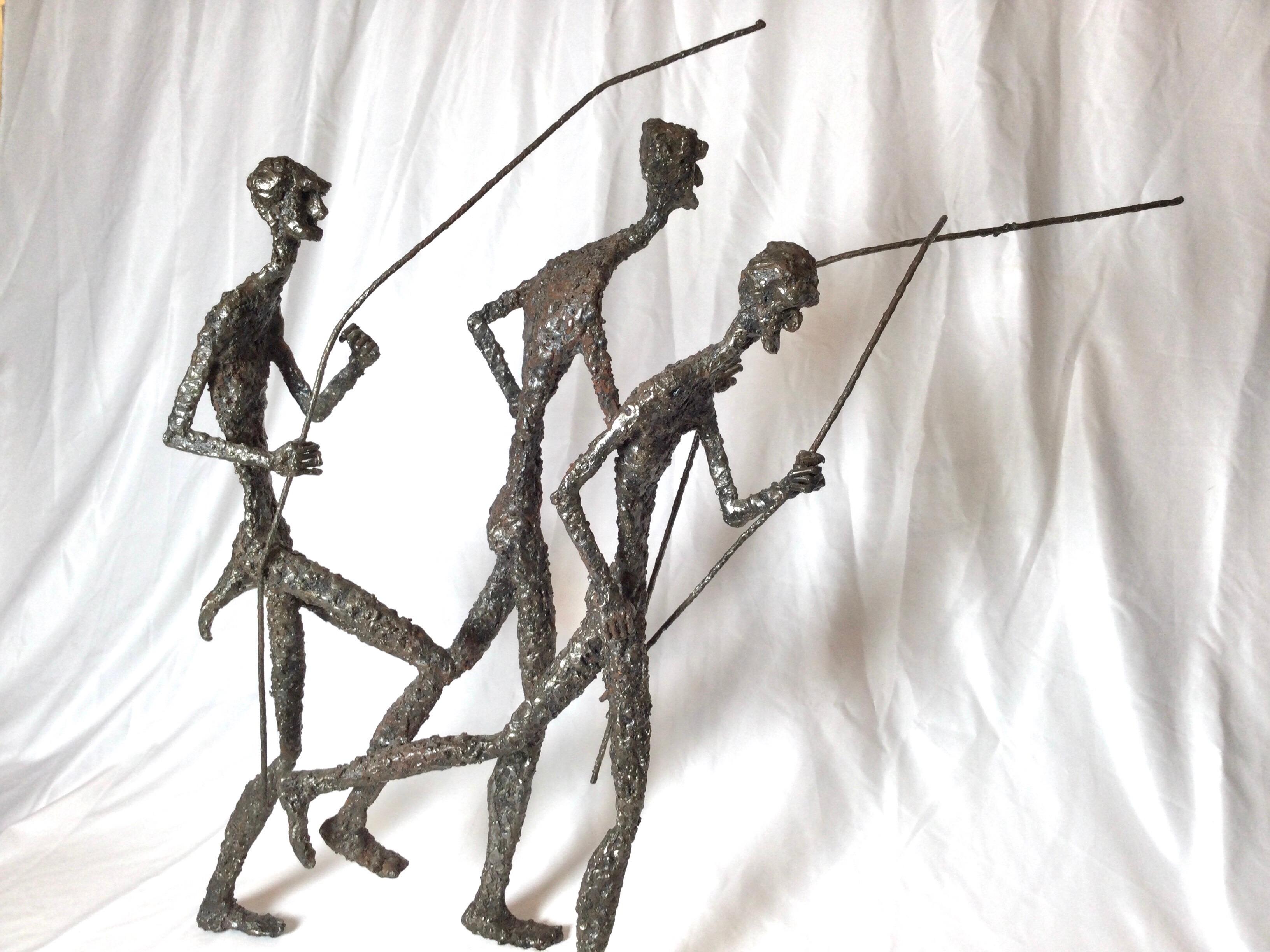 The sculpture with three figures in motion with shafts and hunting spears. The heavy metal sculpture is probably steel. Attributed to Daniel Gluck who is an American artist and furniture designer who was born in the 20th century.