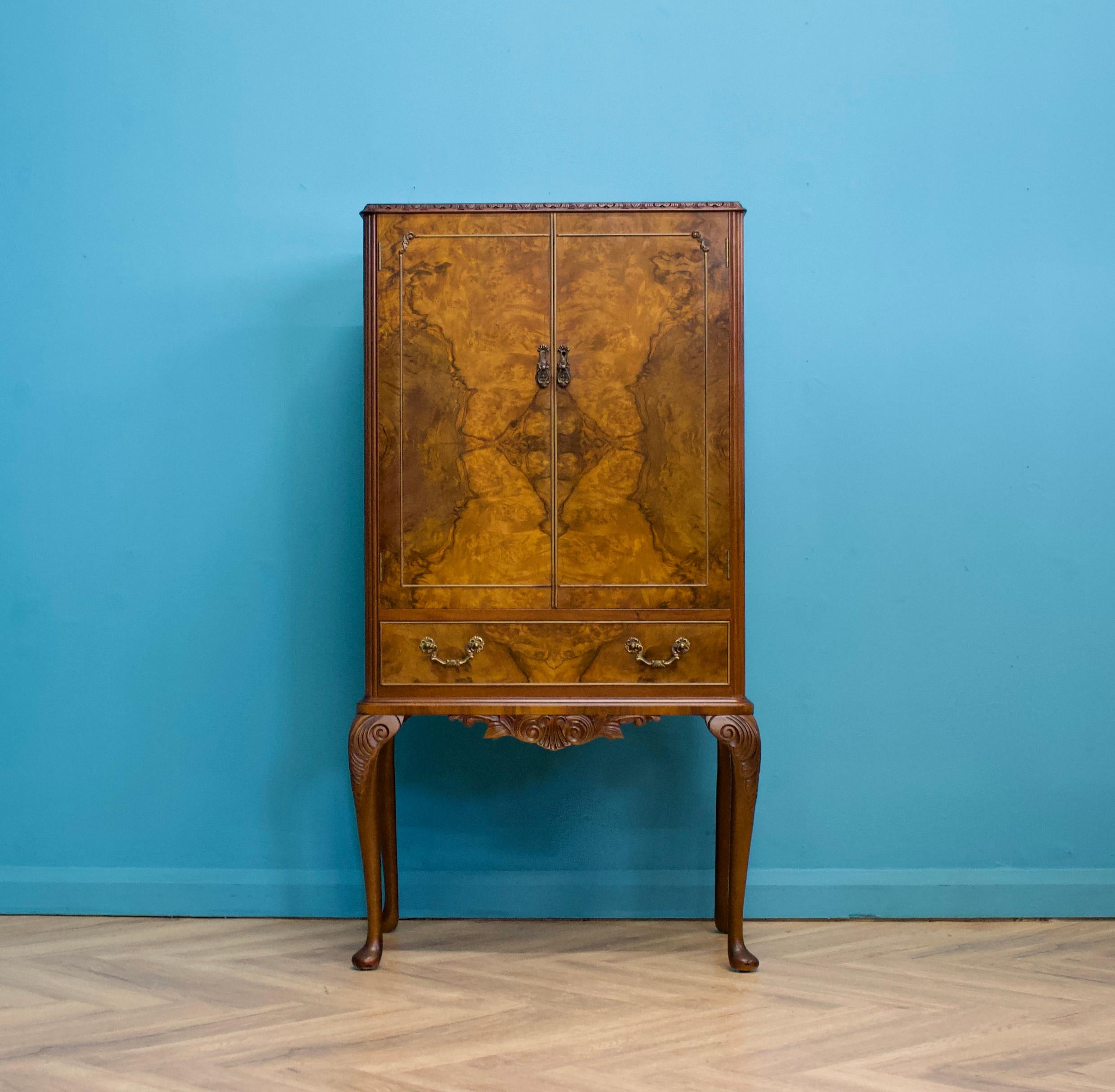 A beautiful quality vintage burr walnut antique style drinks cabinet- in the Queen Anne style

Featuring a mirror backed interior, pull out serving tray and a glass shelf

There is also a drawer to the bottom