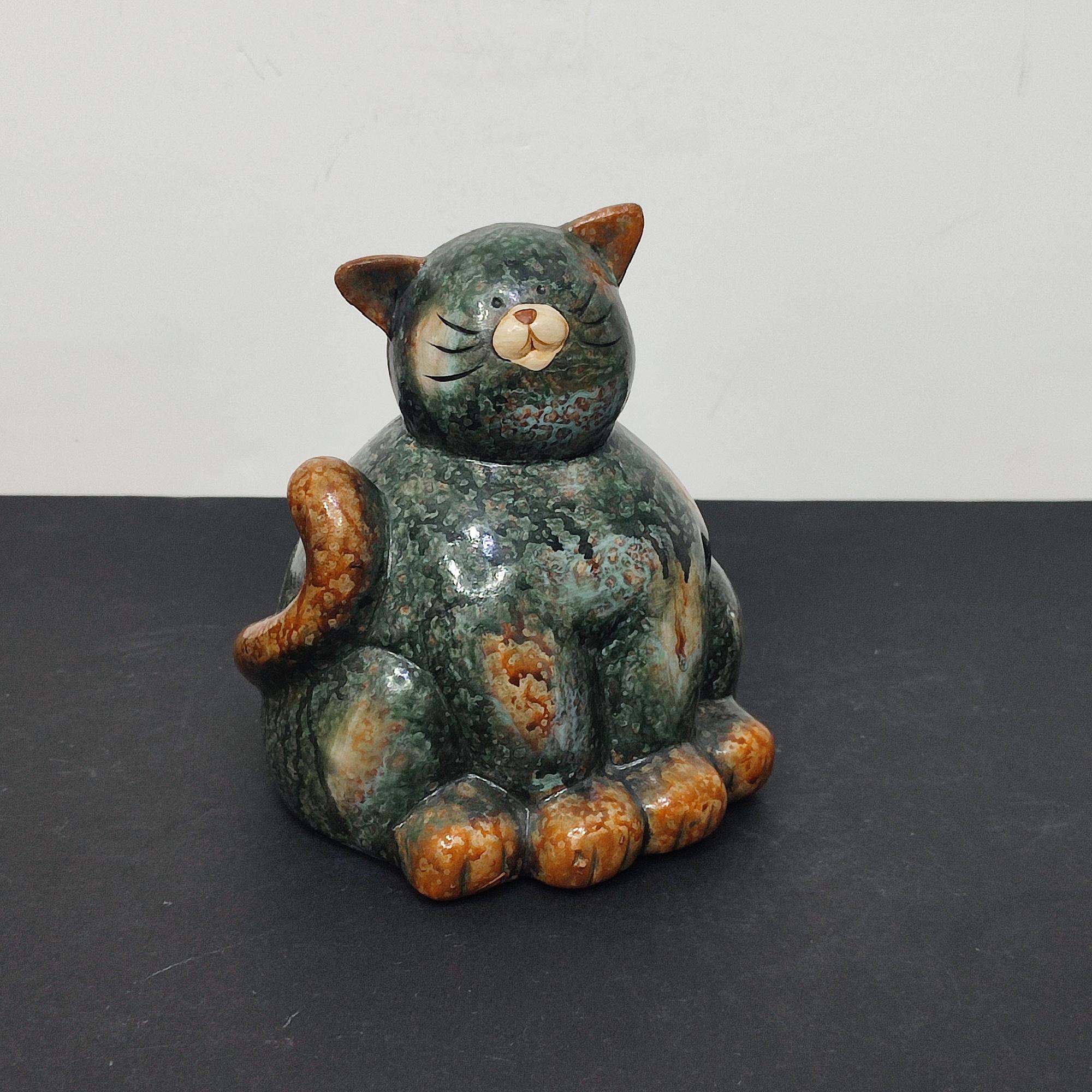 Un'impressionante statuetta di gatto grasso in ceramica della metà del secolo scorso che aggiungerà un tocco di rustica eleganza alla tua collezione.
Questo sereno felino è caratterizzato da:
- Una posa seduta con le zampe anteriori a terra e la