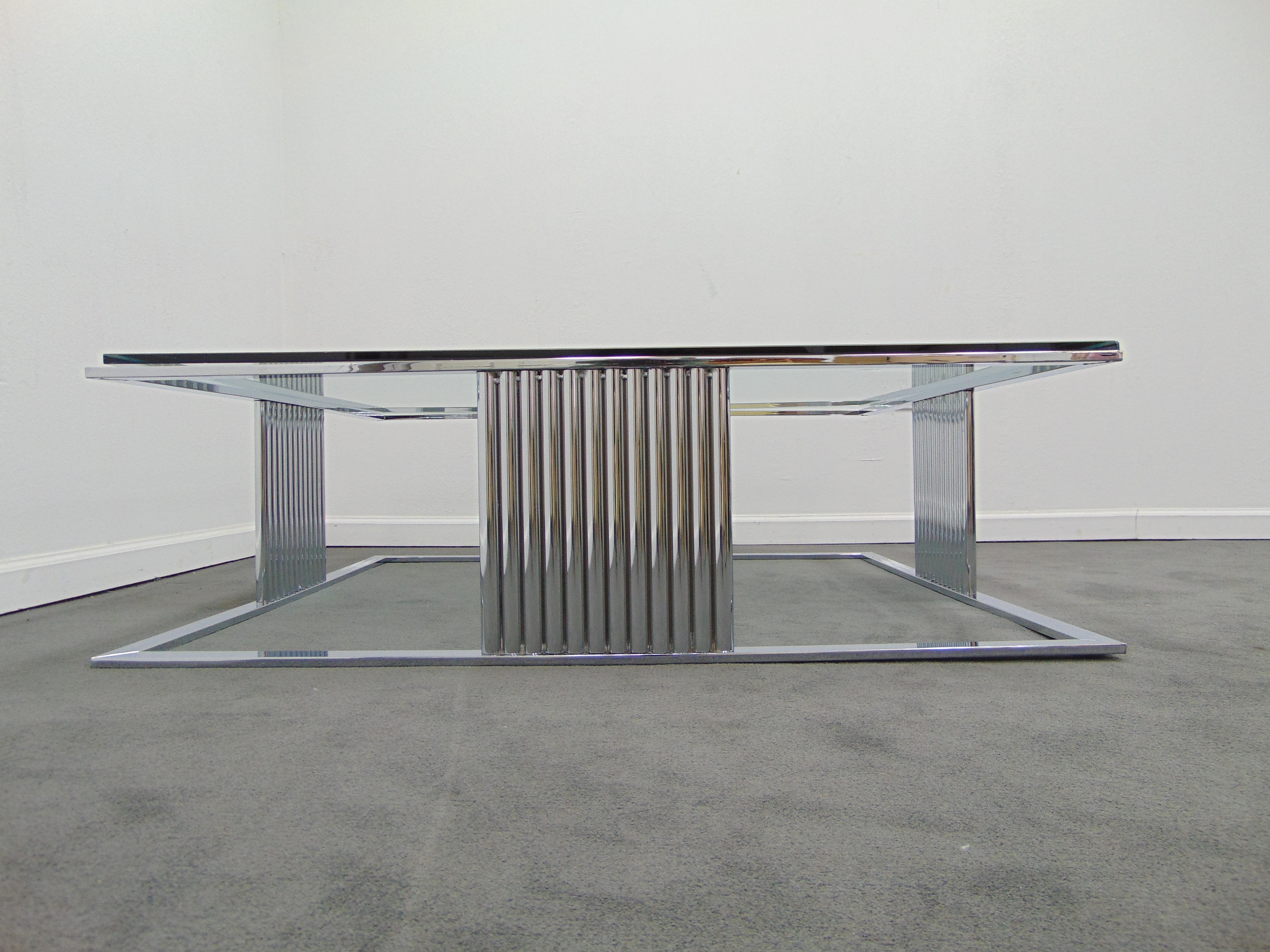 This is a vintage midcentury shiny chrome and glass top large square coffee table from the 1970s. The coffee table is perfect for a large room and sits low. The dimensions are: 18'' H x 49'' L x 49'' W.