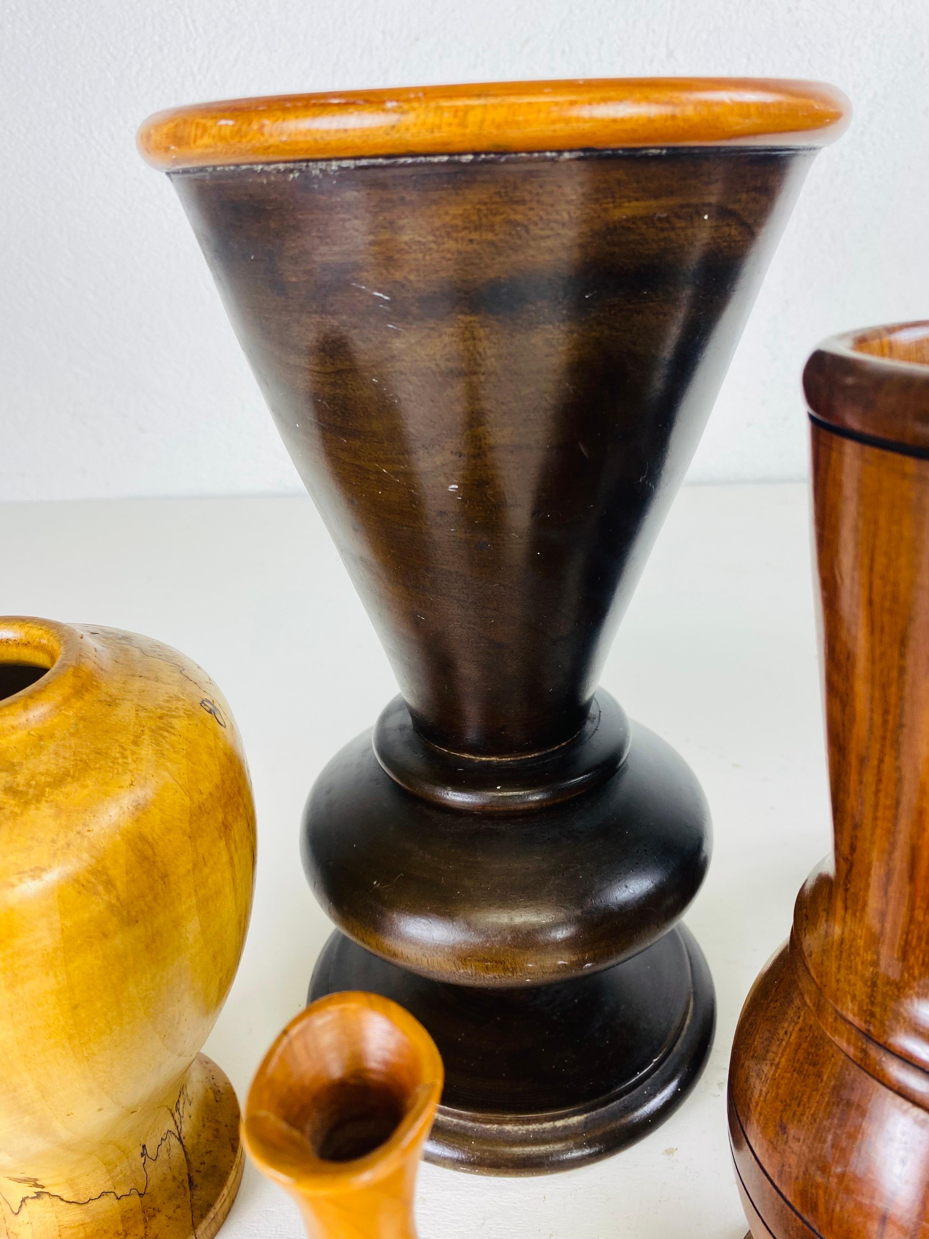 This is a complementary collection of mid century hand turned wooden vessels. Please note the measurements for these pieces are from left to right starting with the blonde vase on the far left measures 4 1/2 x 4 1/2 x 7 1/2 tall. The two large