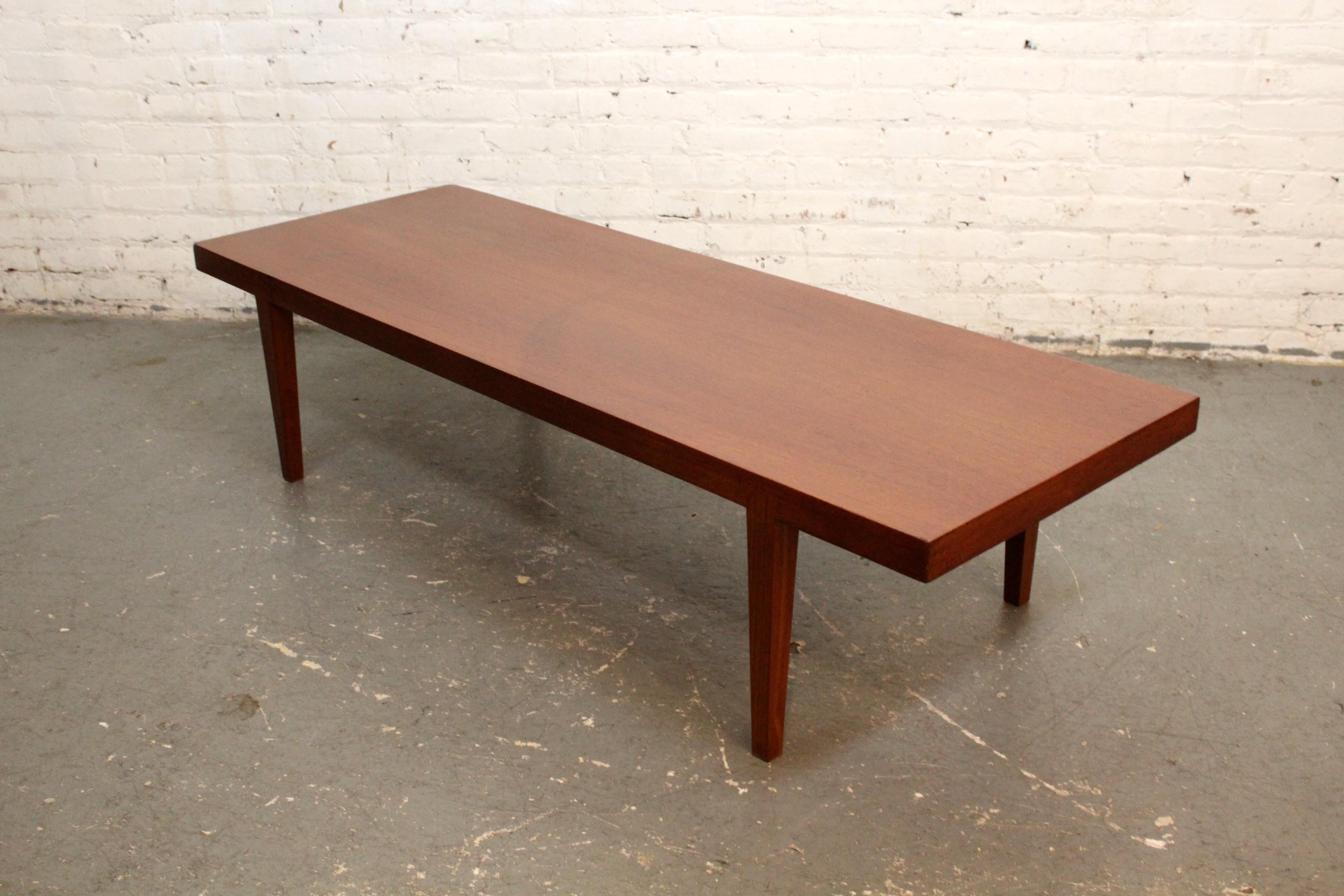 Dieser zeitlose, moderne Couchtisch aus der Mitte des Jahrhunderts, ein beeindruckendes Stück dänischer Handwerkskunst, wertet Ihren Wohnraum auf. Dieser Tisch aus reichem Teakholz strahlt die Wärme und Raffinesse aus, die für die ikonische