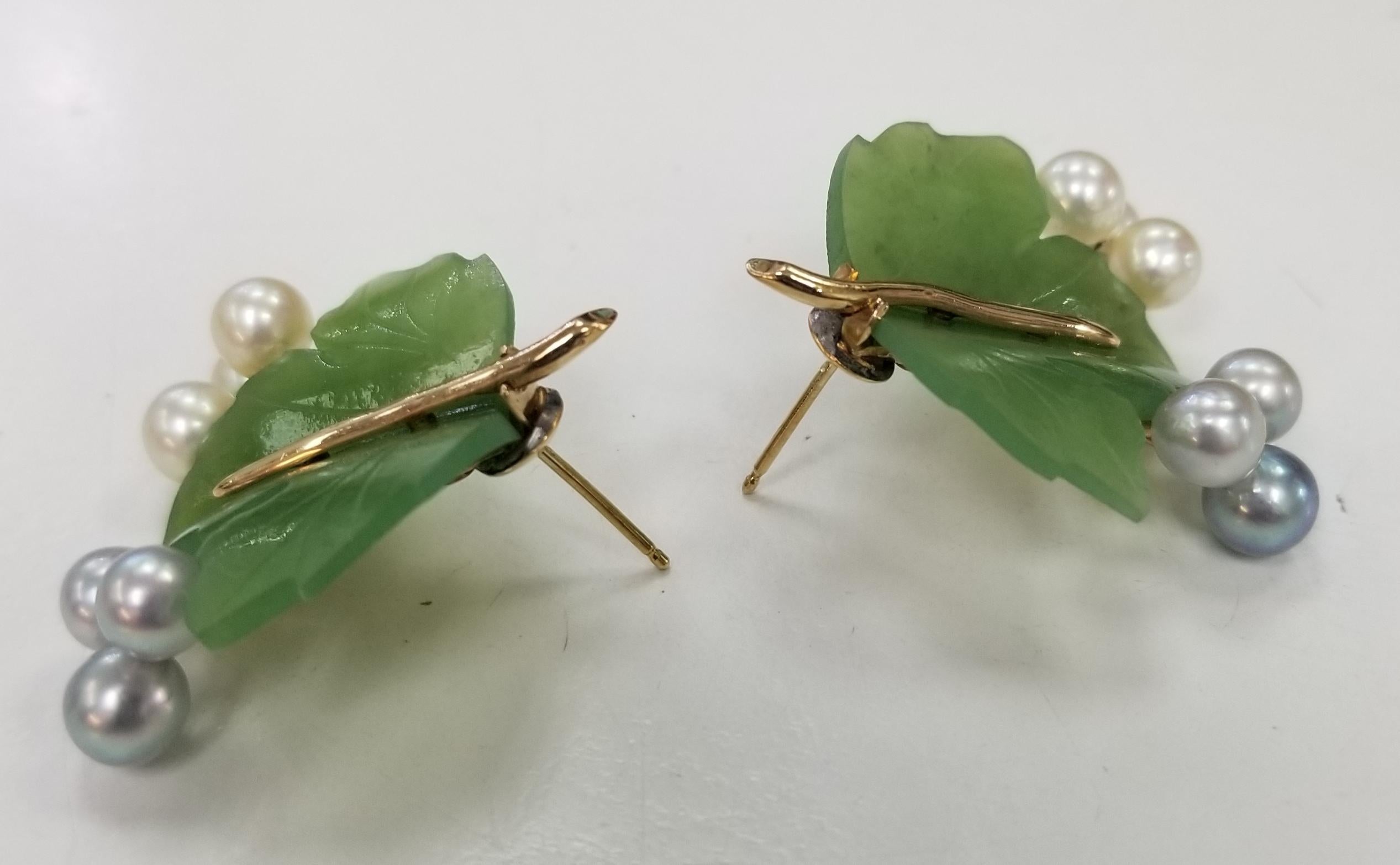 This gorgeous, Mid Century vintage earrings,  features carved nephrite and pearls in a 14 karat gold floral motif. 
There are two (2) carved nephrite jade leaves, each carved by hand and 12 pearls measuring 5-6mm(the piece is old enough that the