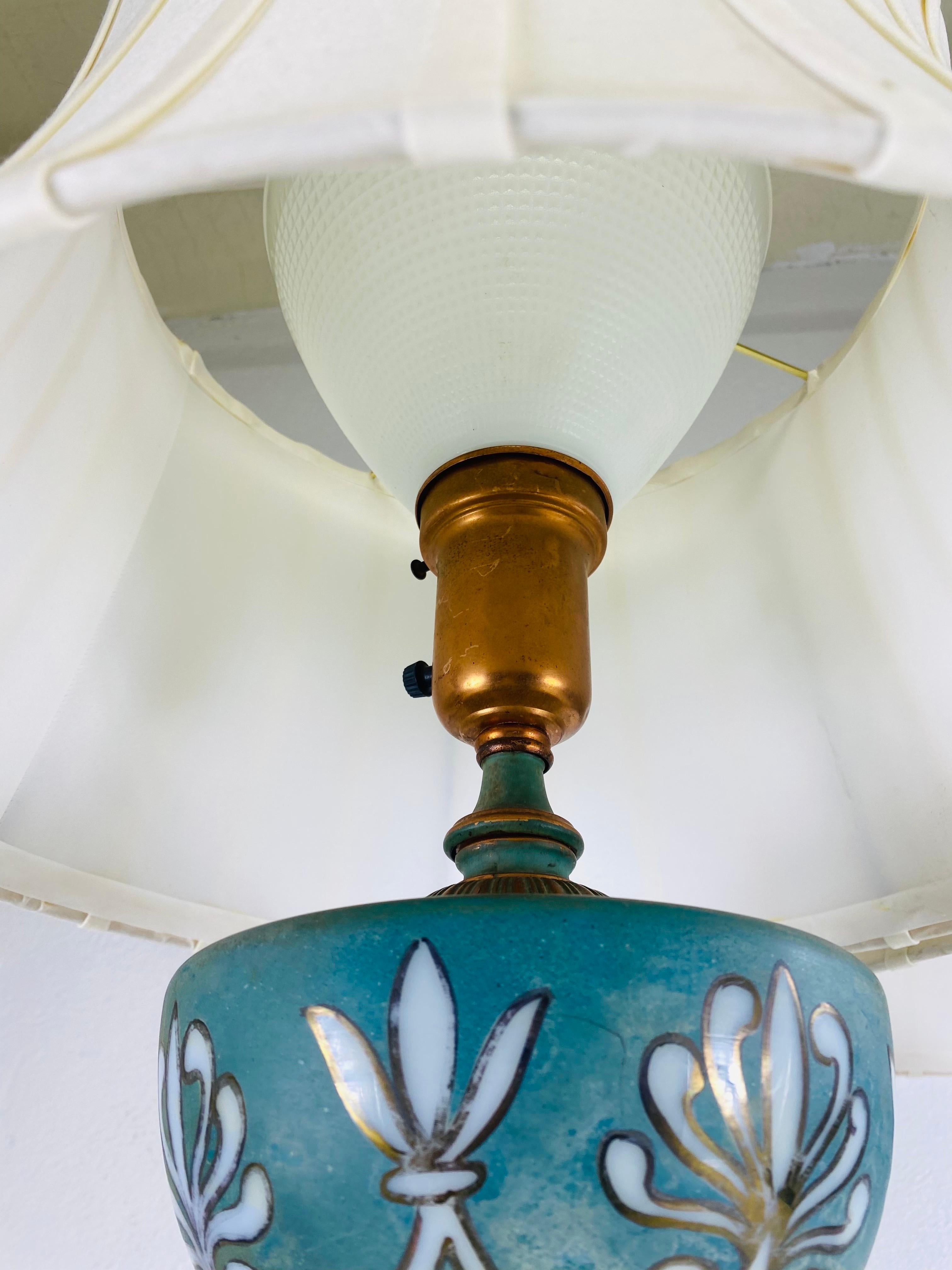 Se trata de un par de lámparas de sobremesa de estilo neoclásico vintage de mediados de siglo. Estas lámparas tienen un matiz cobrizo con una hermosa pátina verde patinada. Estas lámparas tienen una decoración de cristal soplado y pintado a mano en