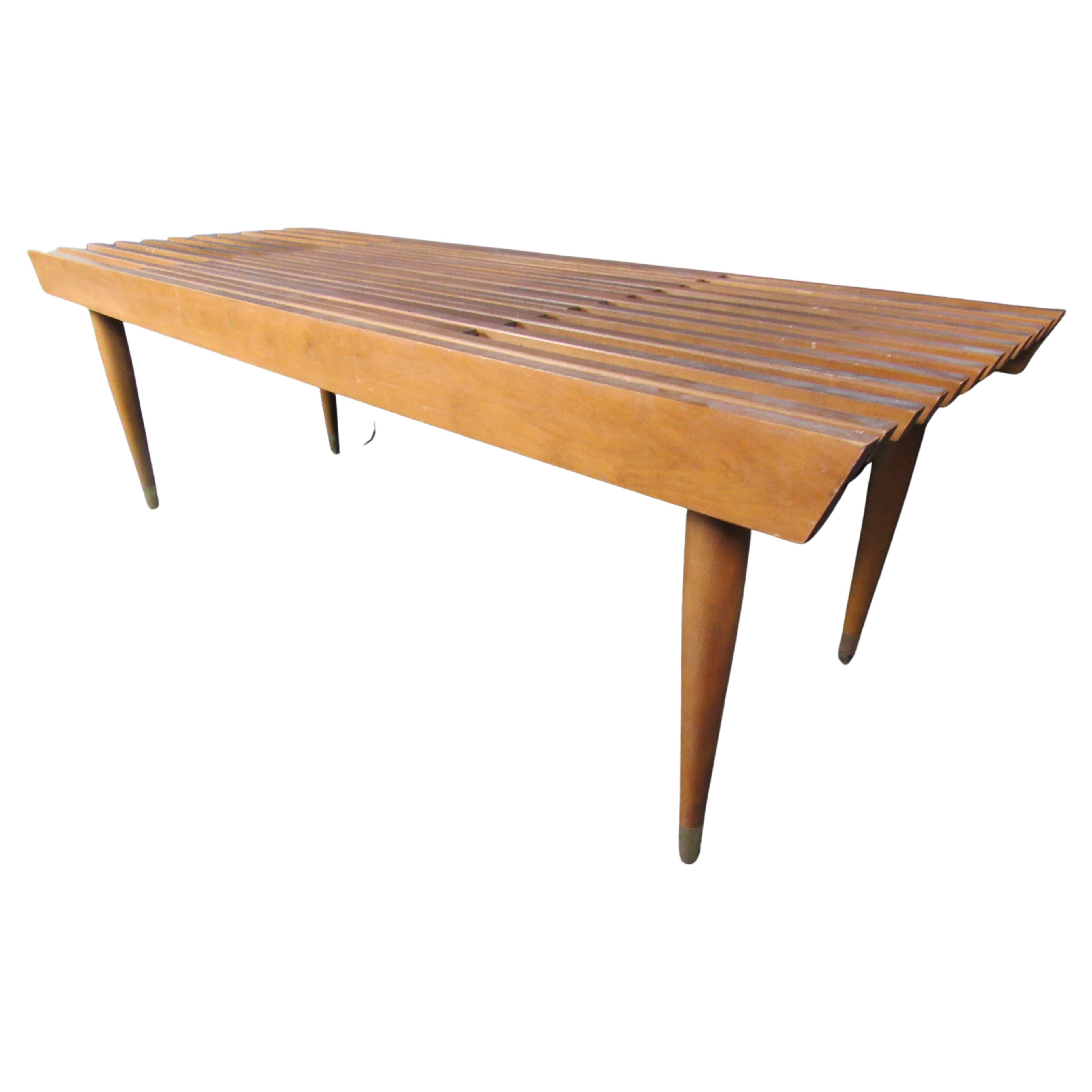 stand out in the Mid-Century Modern crowd with this unique extending walnut slat bench! While borrowing inspiration from the famed designs of George Nelson, the interlocking, sliding slats give this transformative table a life of it's own! Whether