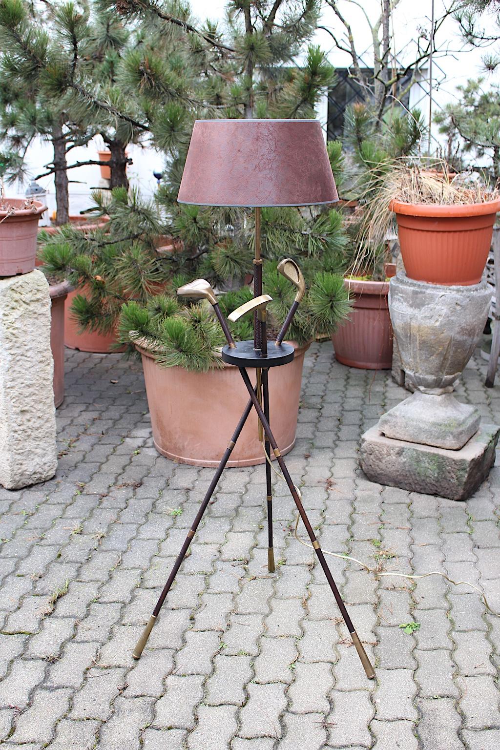 An extraordinary high quality vintage golf club floor lamp attributed to Jacques Adnet 1940s France, which was made out of stitched leather, solid brass, brassed metal and black lacquered wood.
Three different types of golf clubs are held by a