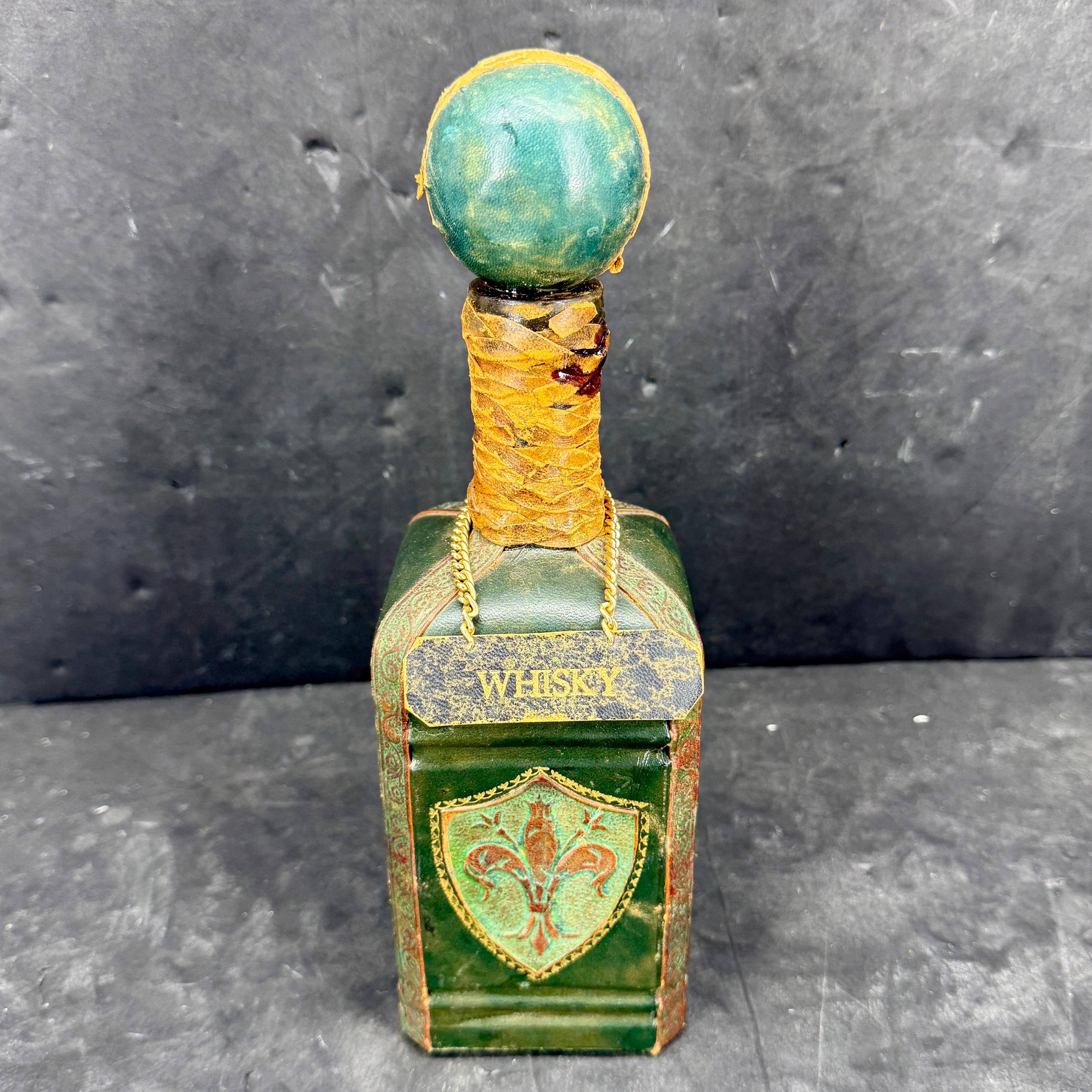 Florentine Leder und Glas Likör Dekanter aus Italien. Dieses atemberaubende Stück weist eine begehrte und unschlagbare Patina mit einem Fleur-de-Lis-Dekor auf. Ein wundervolles Einzelstück, das jede Sammlung ergänzt oder allein auf einem Bücherregal
