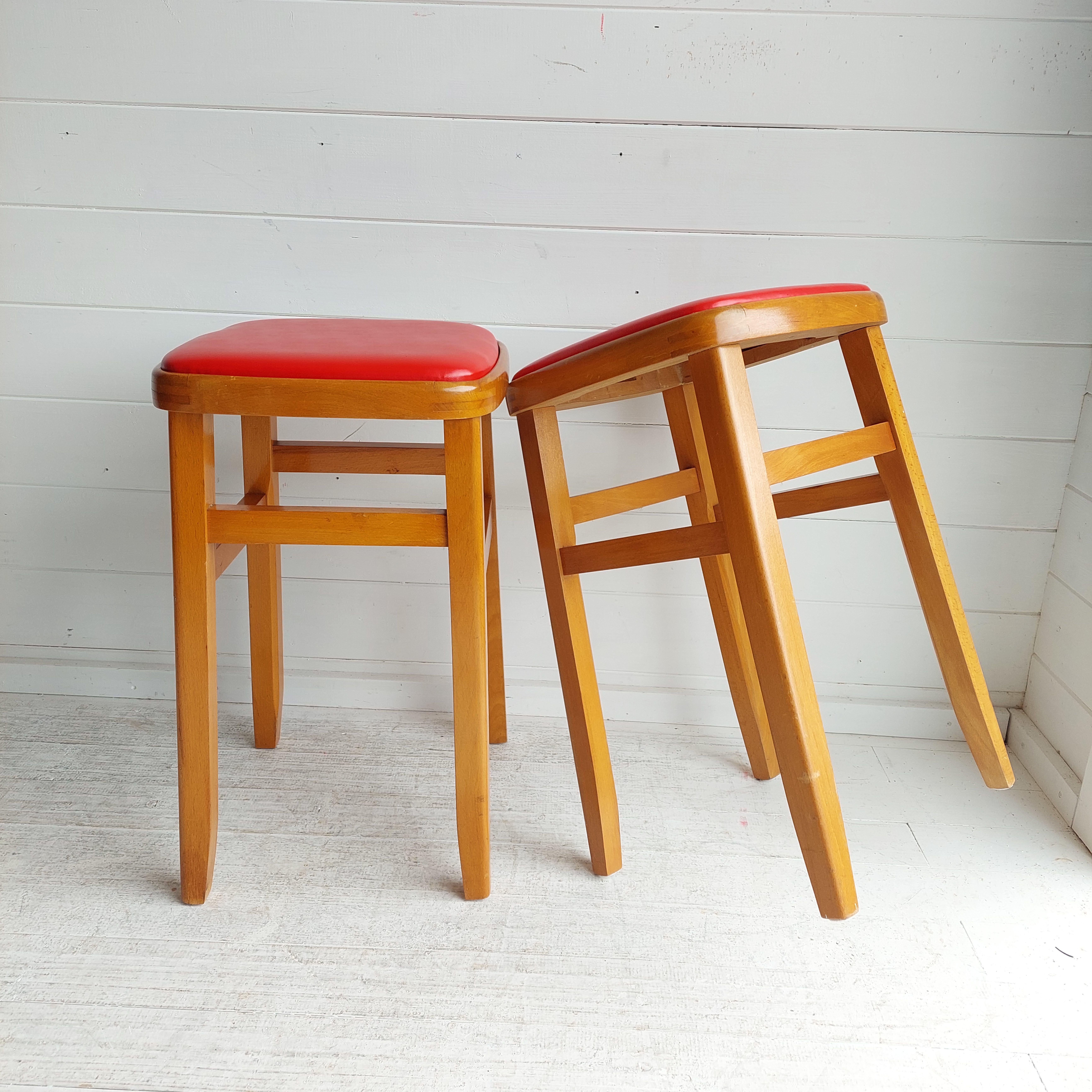 Pair of solid wooden kitchen stool, with leather effect / vinyl tops.
A pair of classic beech frame stools. 
Made in their millions in the 1960s, good survivors after 60 years of service

Vintage Kitchen Stool Beech Wood with Red Vinyl Cover Mid