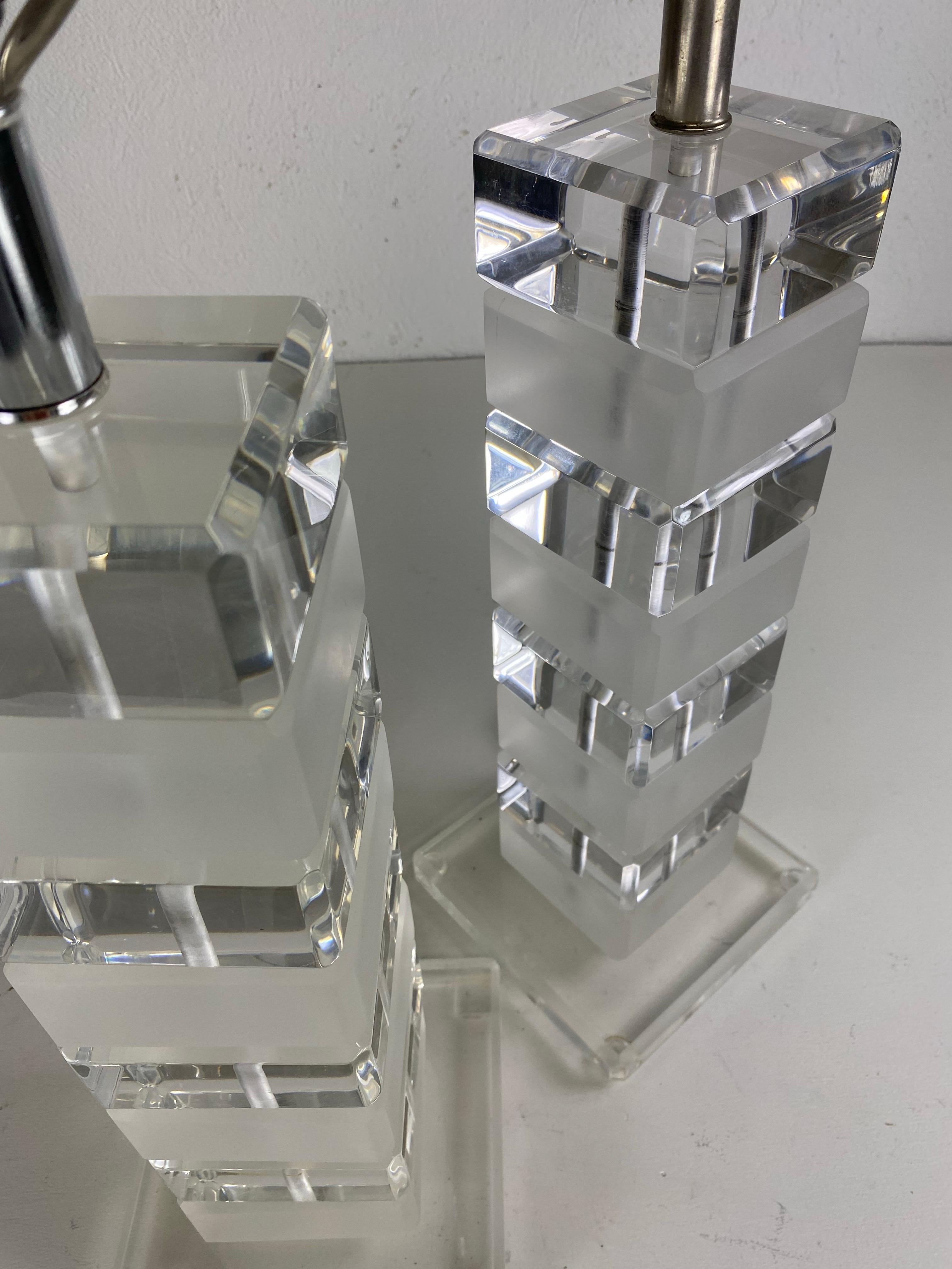 Il s'agit d'une paire de lampes de table en Lucite datant du milieu du siècle dernier. Cette paire de lampes est composée de blocs de Lucite solides qui sont empilés pour créer l'effet de colonne. Les blocs sont trop toniques, l'un transparent et