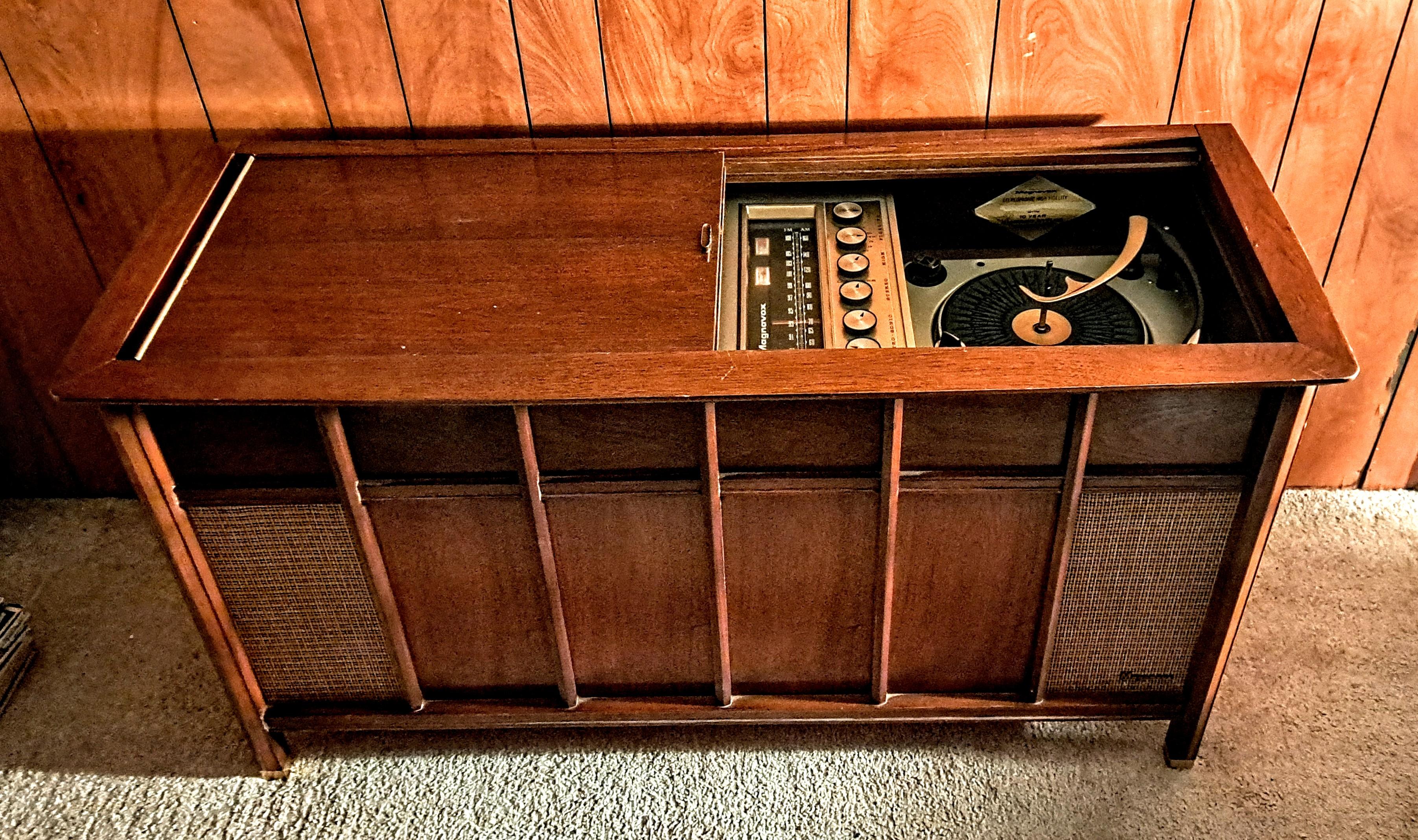 Vintage Nussbaum Magnavox Mitte des Jahrhunderts Plattenwechsler Stereo-Konsole mit Lautsprechern, AM-FM-Radio, Ablagefläche und  Plattenspieler mit der Möglichkeit, einzelne oder mehrere Platten abzuspielen.