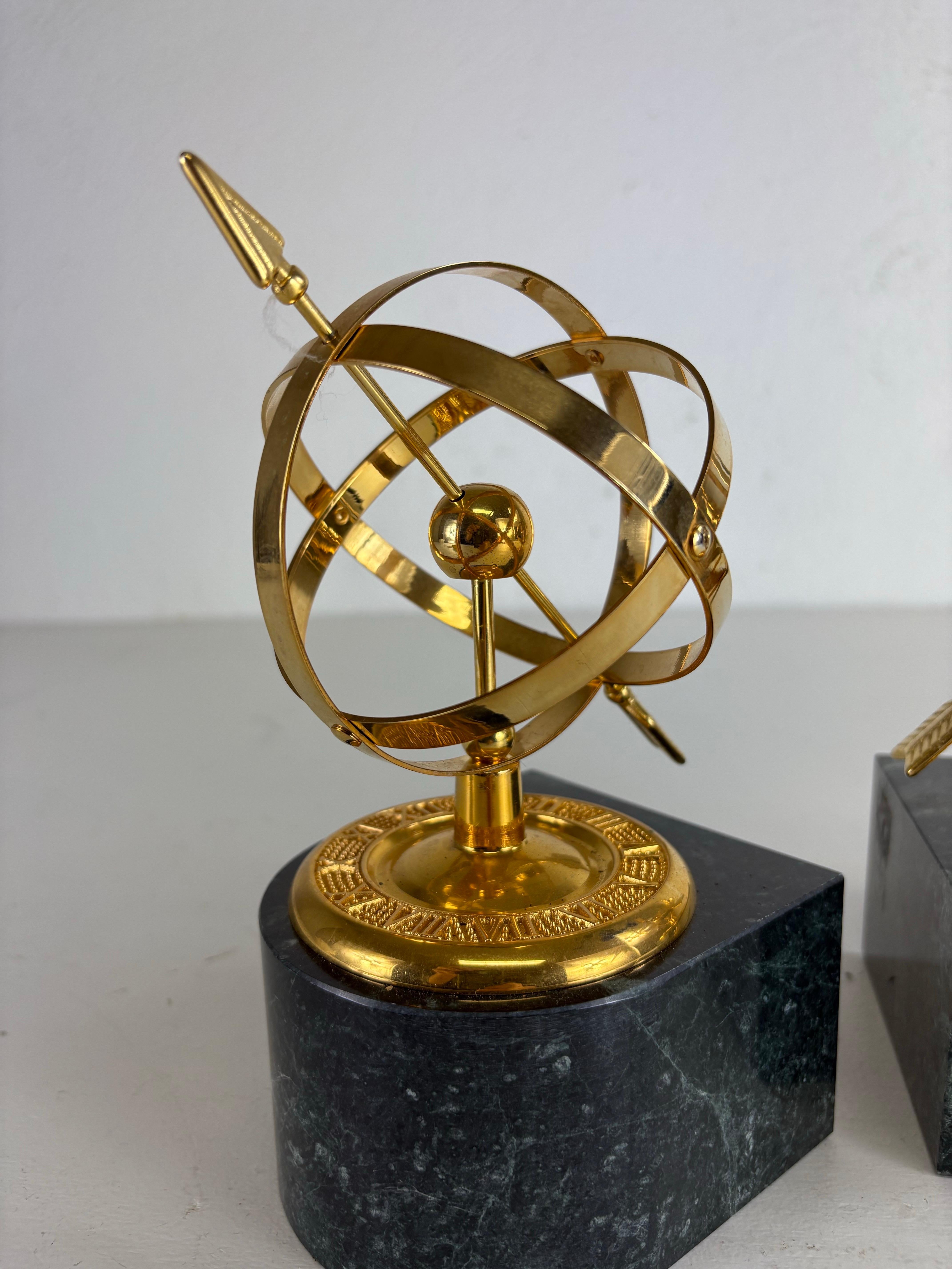 Si tratta di una coppia di reggilibri Armillary in ottone e marmo della metà del secolo scorso. Questi fermalibri hanno una base in marmo verde scuro con venature nere e una forma armillare in ottone massiccio nella parte superiore. Ciascuna