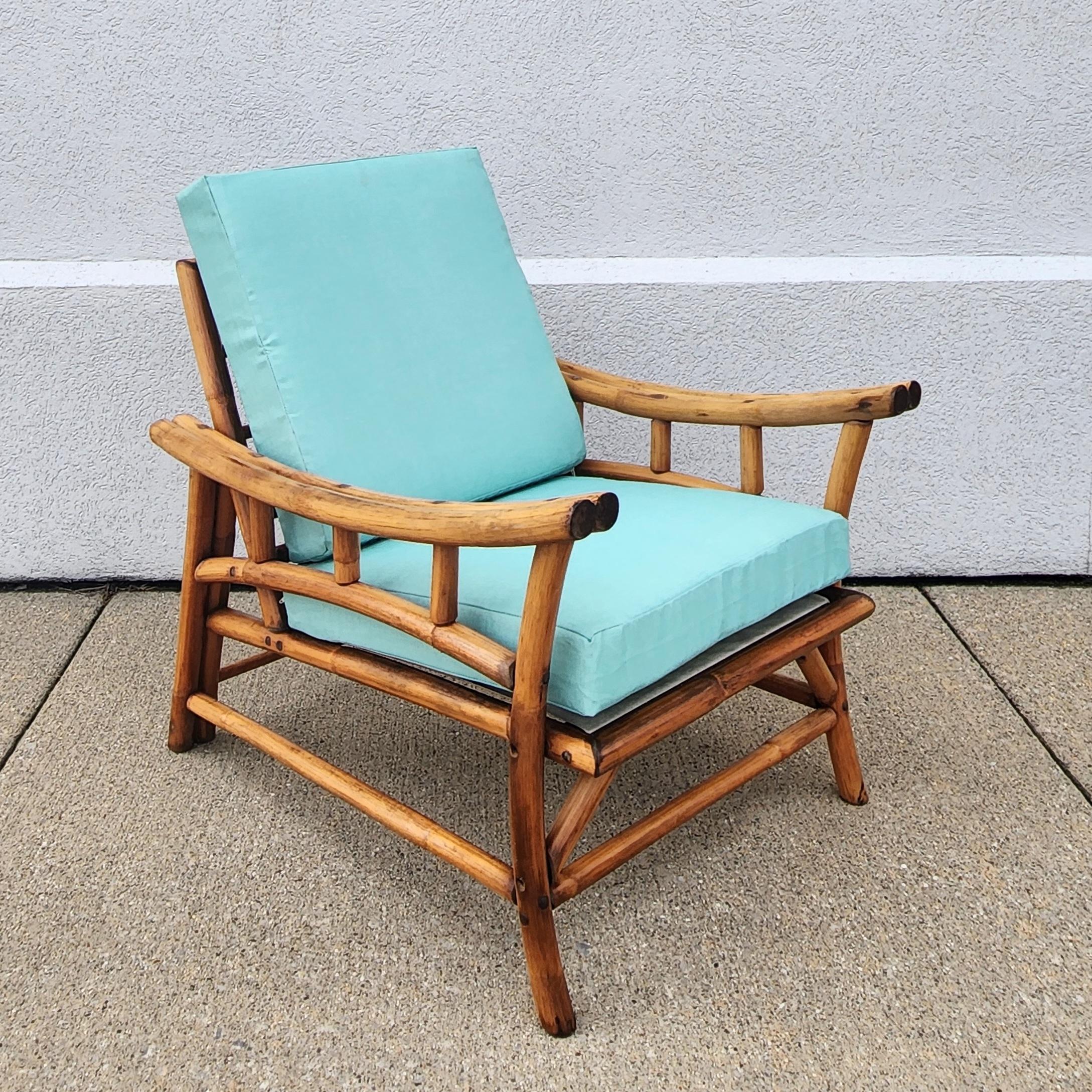 This is a unique Ficks Reed rattan side chair. Complete with new turquoise blue cushions that resemble a grass cloth finish. It has an original natural amber brown colored finish with a beautiful sculptural form. Wire coil type bottom and two metal