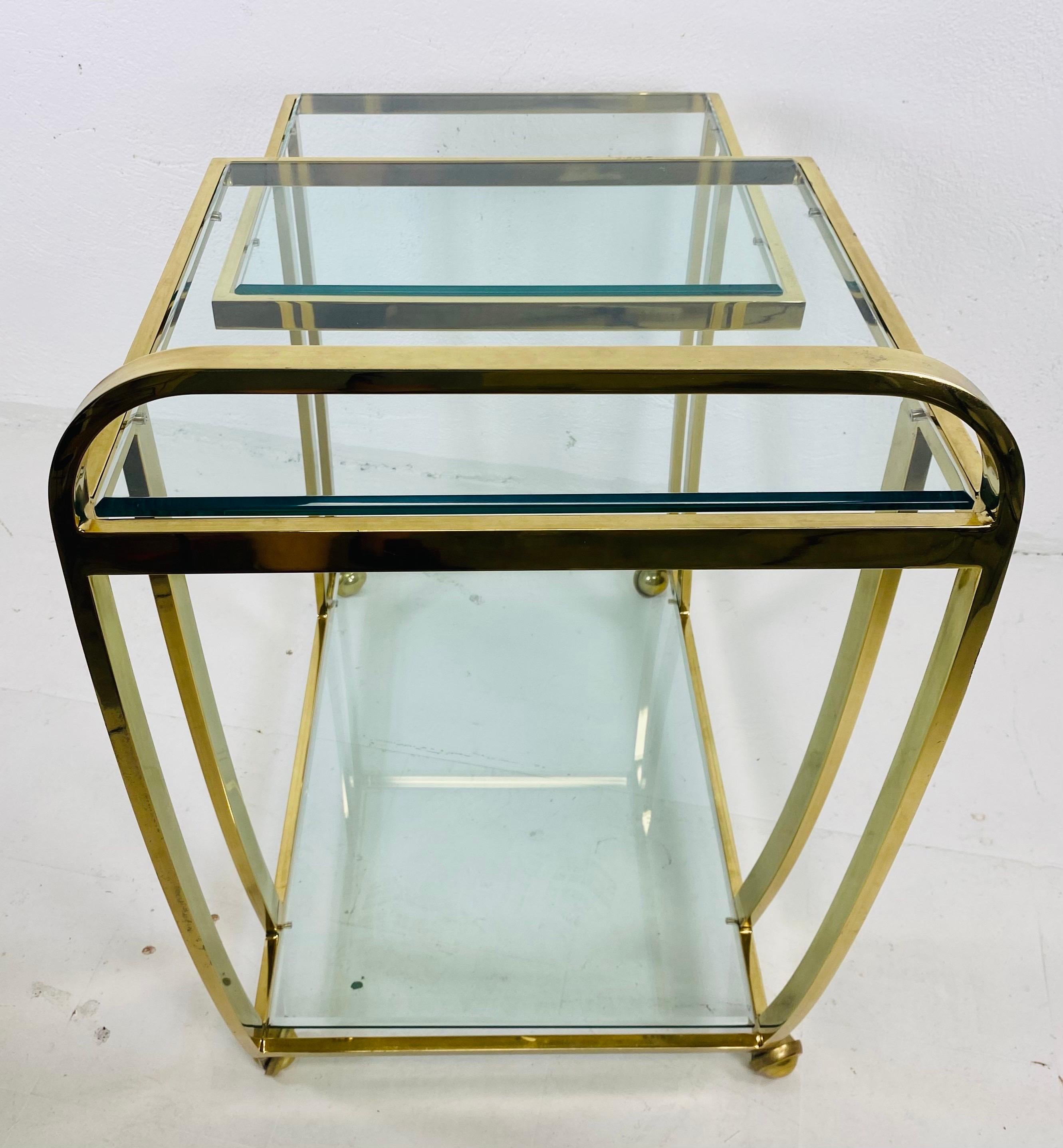 Se trata de un carrito de bar vintage de mediados de siglo, obra del diseñador Milo Baughman. Este carrito de bar de latón macizo tiene tres estantes de cristal encajados en un elegante marco curvilíneo de latón macizo. Este carrito de bar está en
