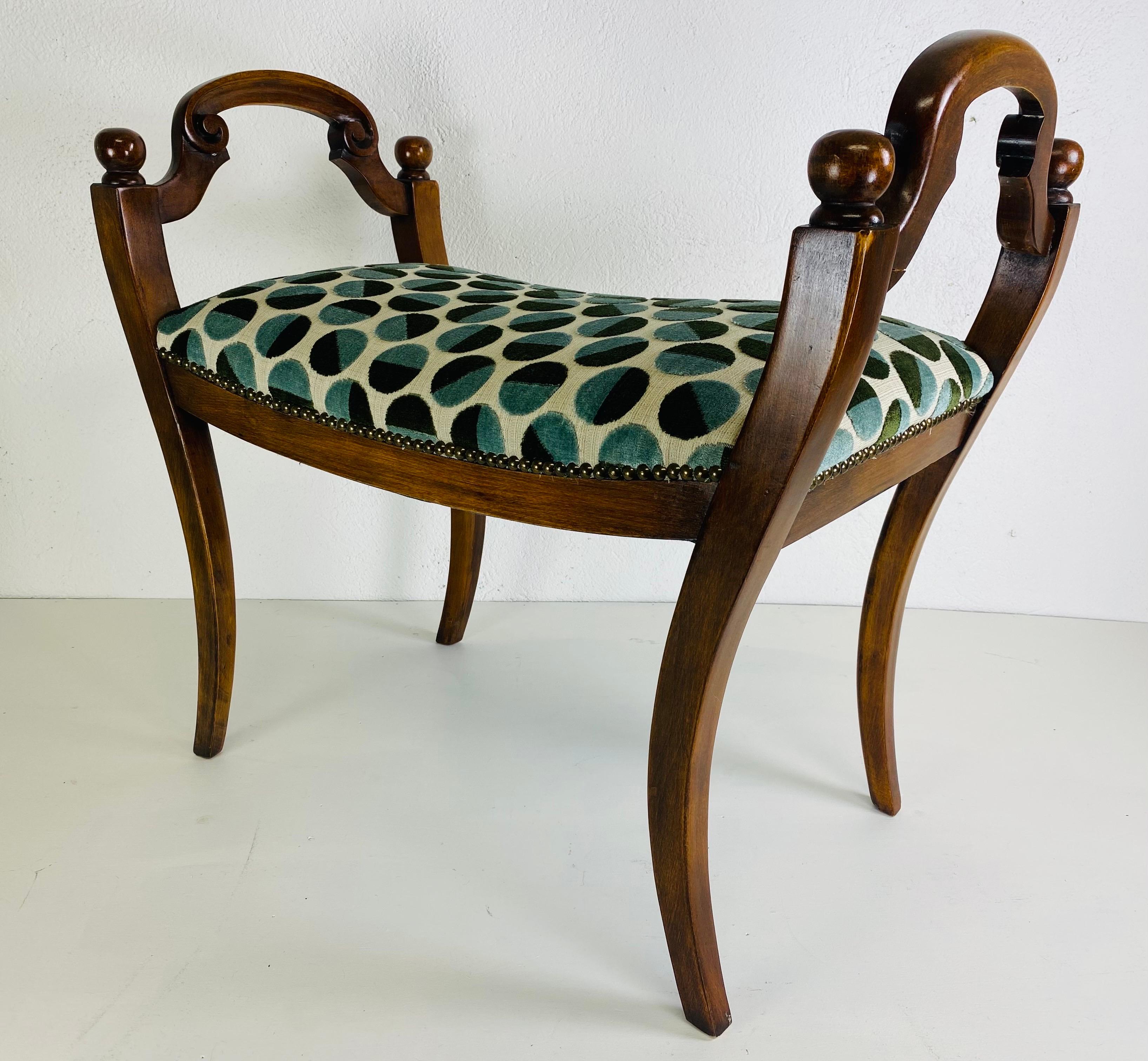 This is a mid century vintage newly upholstered Italian bench. This bench has a soft rococo carved frame with soft curved Klismos legs. The bench is upholstered in a modern polkadot cut velvet. The cut velvet has a cream background with sage and