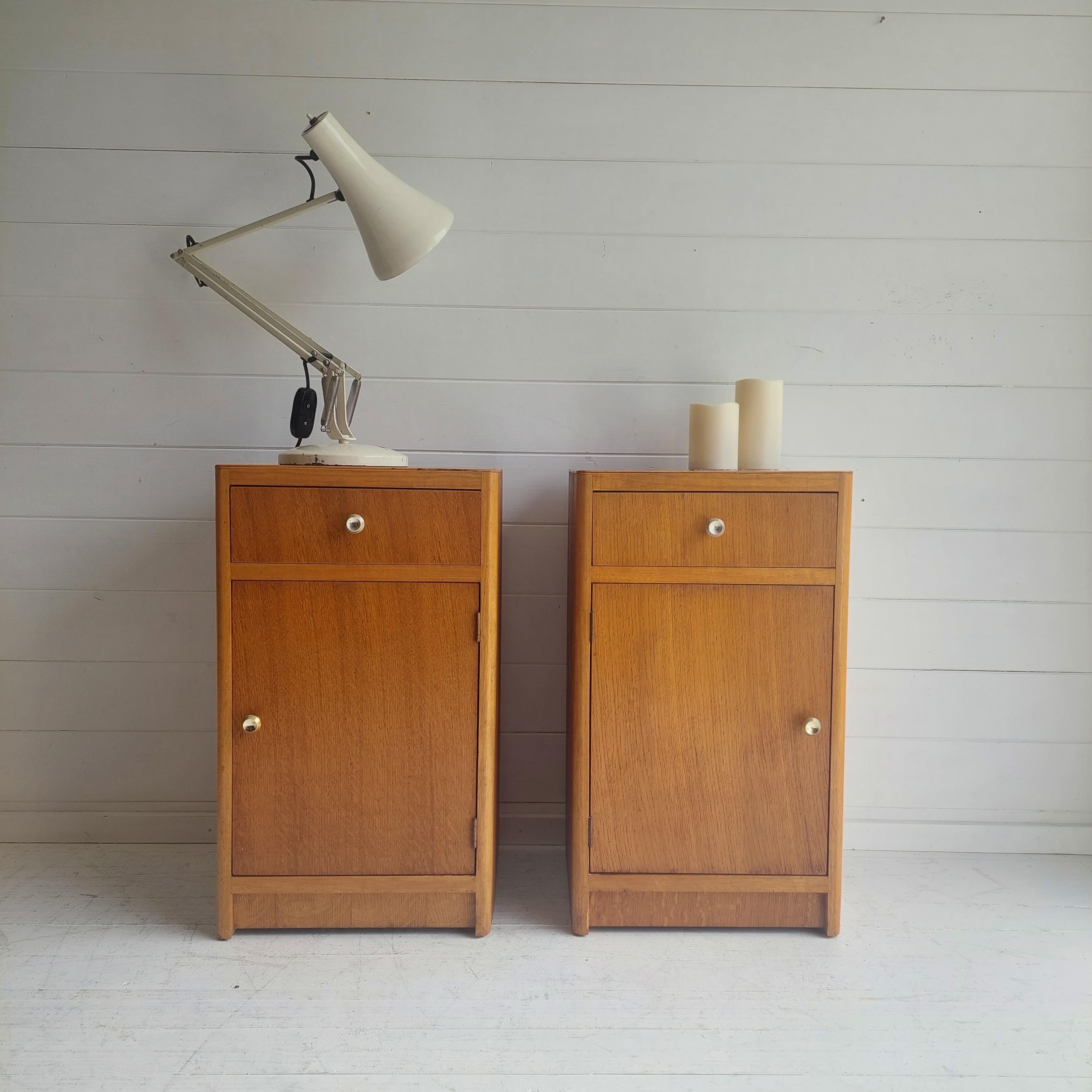 Pair of Vintage Bedside Cabinets
Trully beautiful abd difficult to come across a pair.

Made probably by Meredew in the 1950s, this petite pair of oak cabinets with brass knobs are designed to sit either side of the bed. 
Each has a drawer and