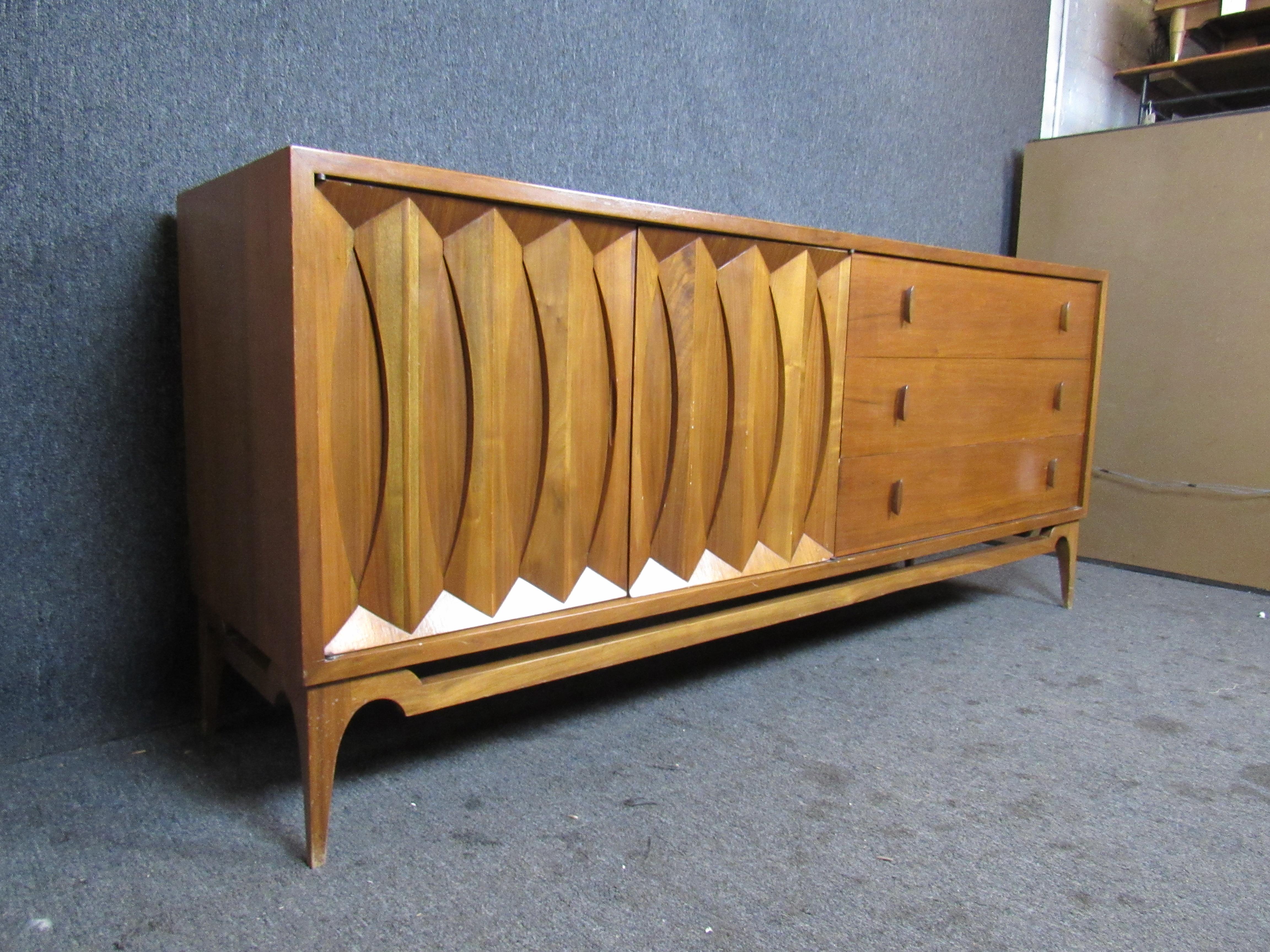 Endlessly interesting vintage Mid-Century Modern walnut credenza with fantastic sculpted details. Two side doors feature a panel of carved bowties reminiscent of the Classic Broyhill Brasilia and Kent Coffey Perspecta lines of the 1950s and '60s.