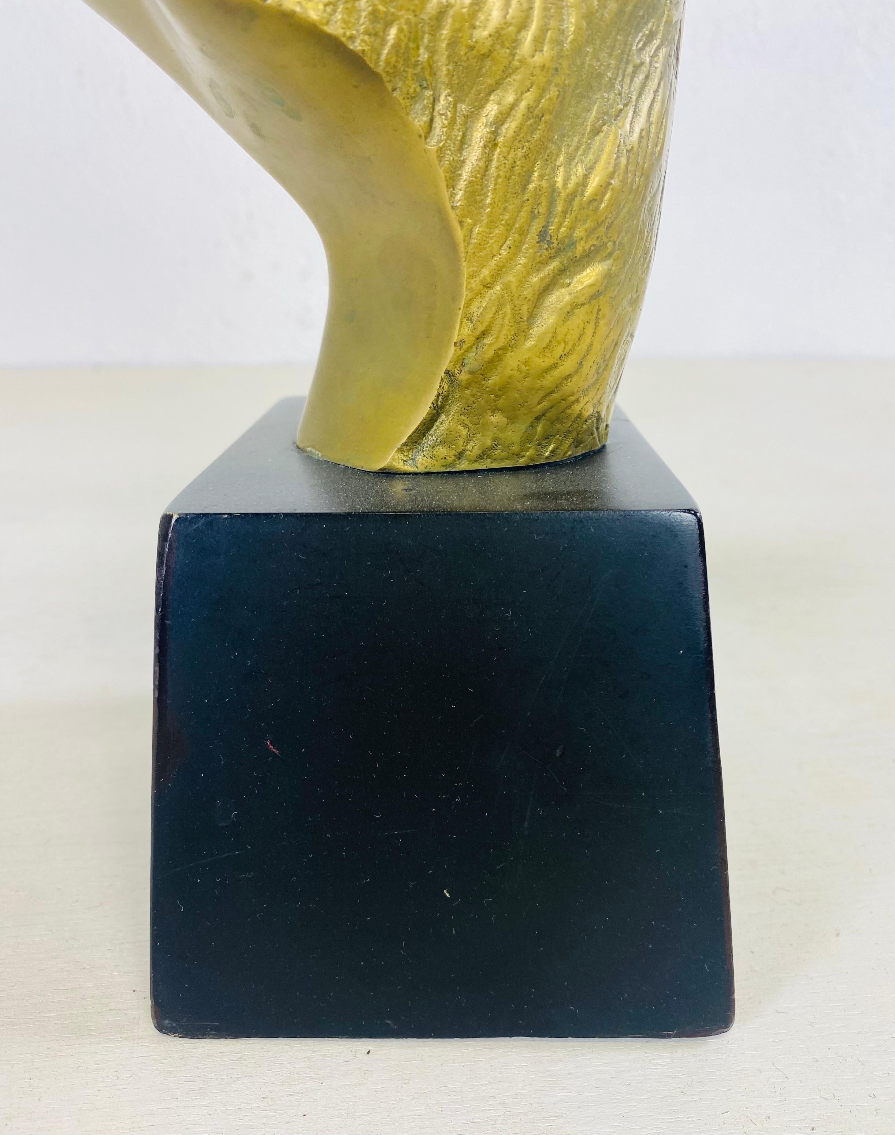 This is a midcentury vintage solid brass bust of a Ramshead. This large Ramshead is hand Chased and Stands on a black wooden pedestal. This Ramshead sculpture it was made in America circa 1978.