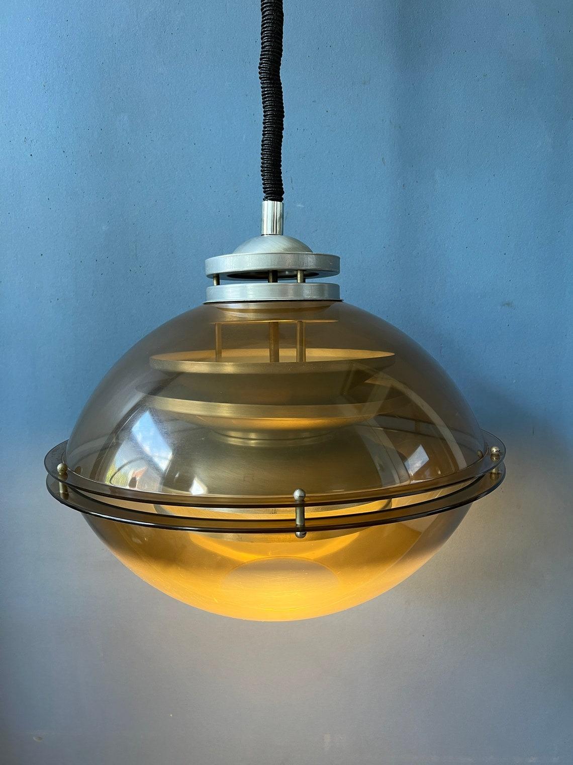 A very special space age pendant light by the Dutch brand Herda. The lamps consists of an brown/copper coloured outer shade and an aluminum inner shade. The lamp requires one E27 lightbulb and currently has an EU-plug.

Additional