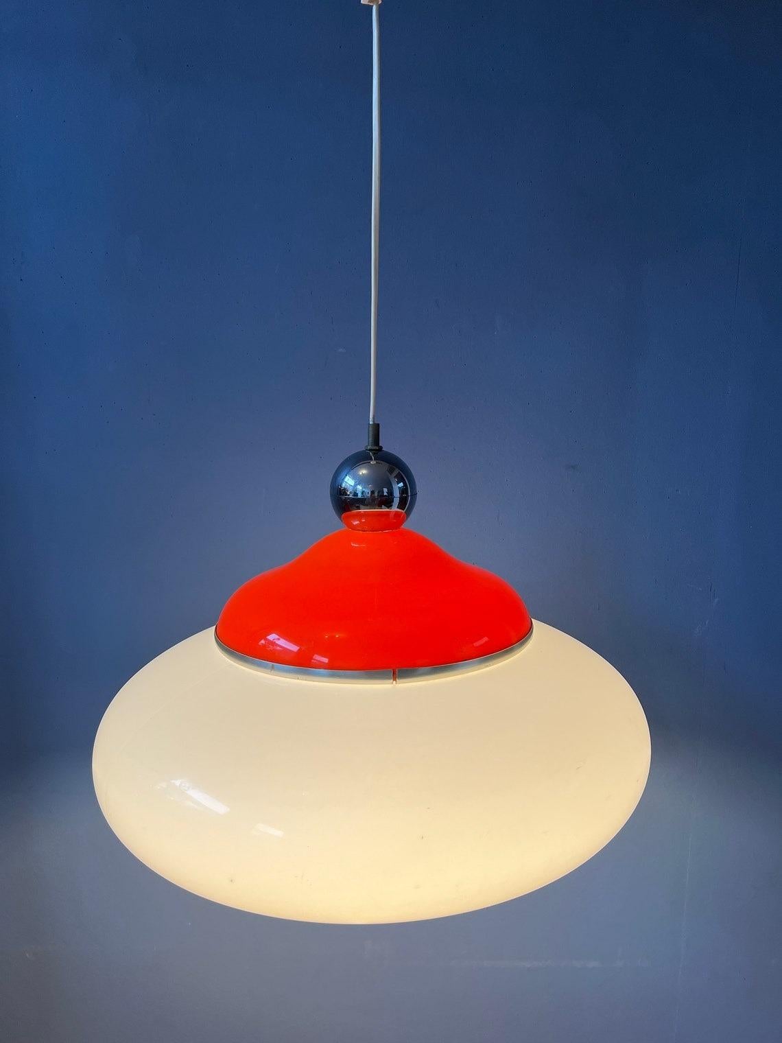 Rare space age pendant lamp with orange and white acrylic glass shade. The lamp produces a warm, cosy light. The lamp requires one E27/26 lightbulb.

Additional information:
Materials: Metal, plastic
Period: 1970s
Dimensions: ø Shade: 34 cm
Height