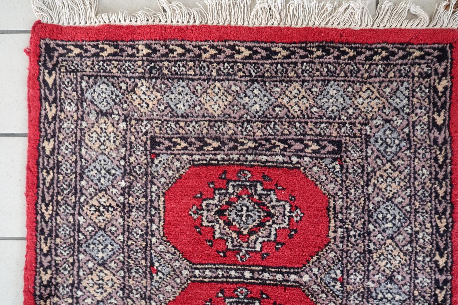 Ce remarquable chemin de table vintage noué à la main est fabriqué dans le style distinctif de Bykhara (Bokhara), un motif souvent associé aux traditions de tissage de l'Ouzbékistan et de l'Asie centrale. Datant des années 1960, cette pièce présente