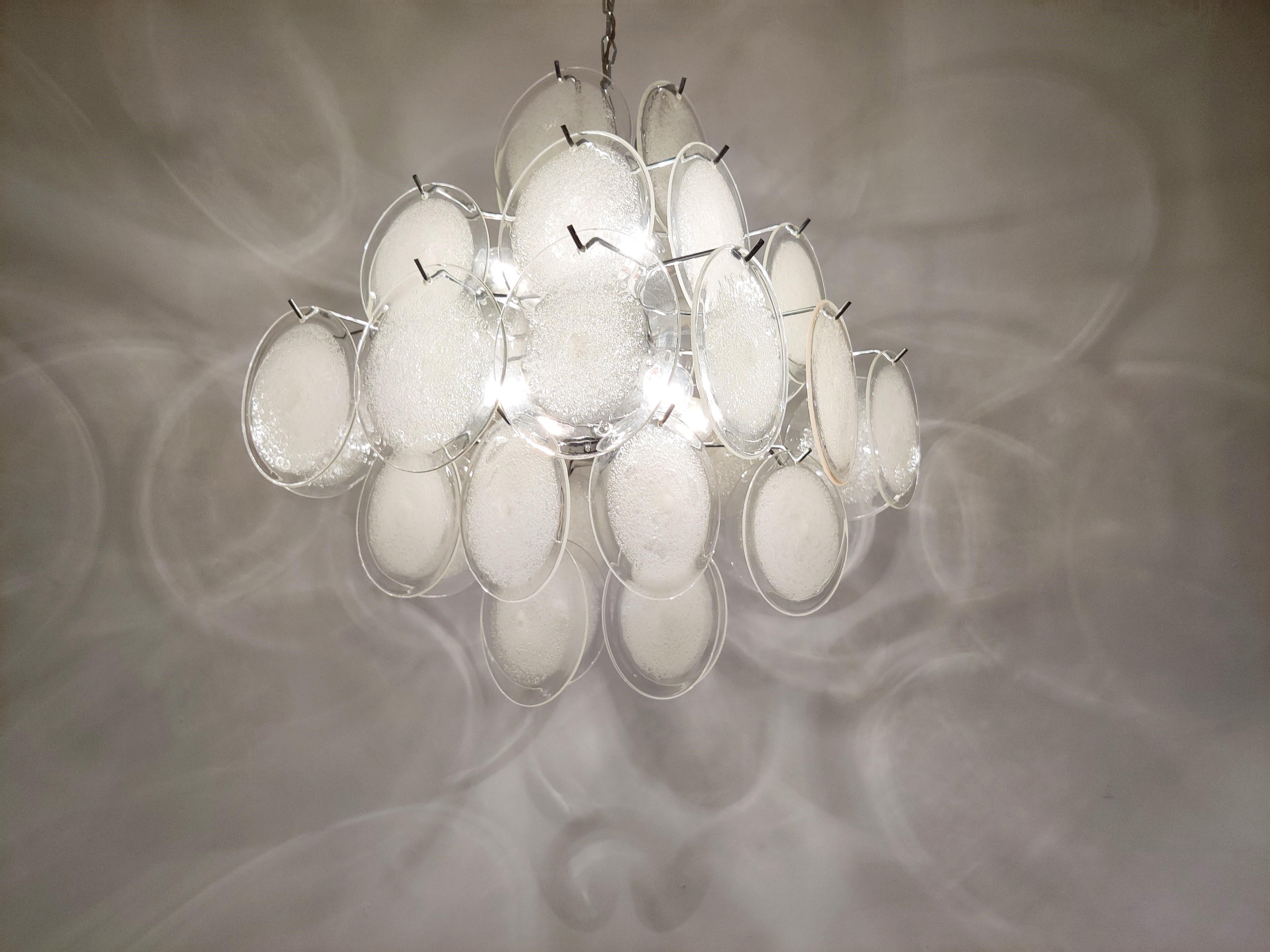 Beautiful chandelier by Vistosi with Murano glass discs.

All discs are handmade which is why none are exactly the same.

The chandelier is in good condition.

The fixture emits a beautiful light and works with regular E14 light