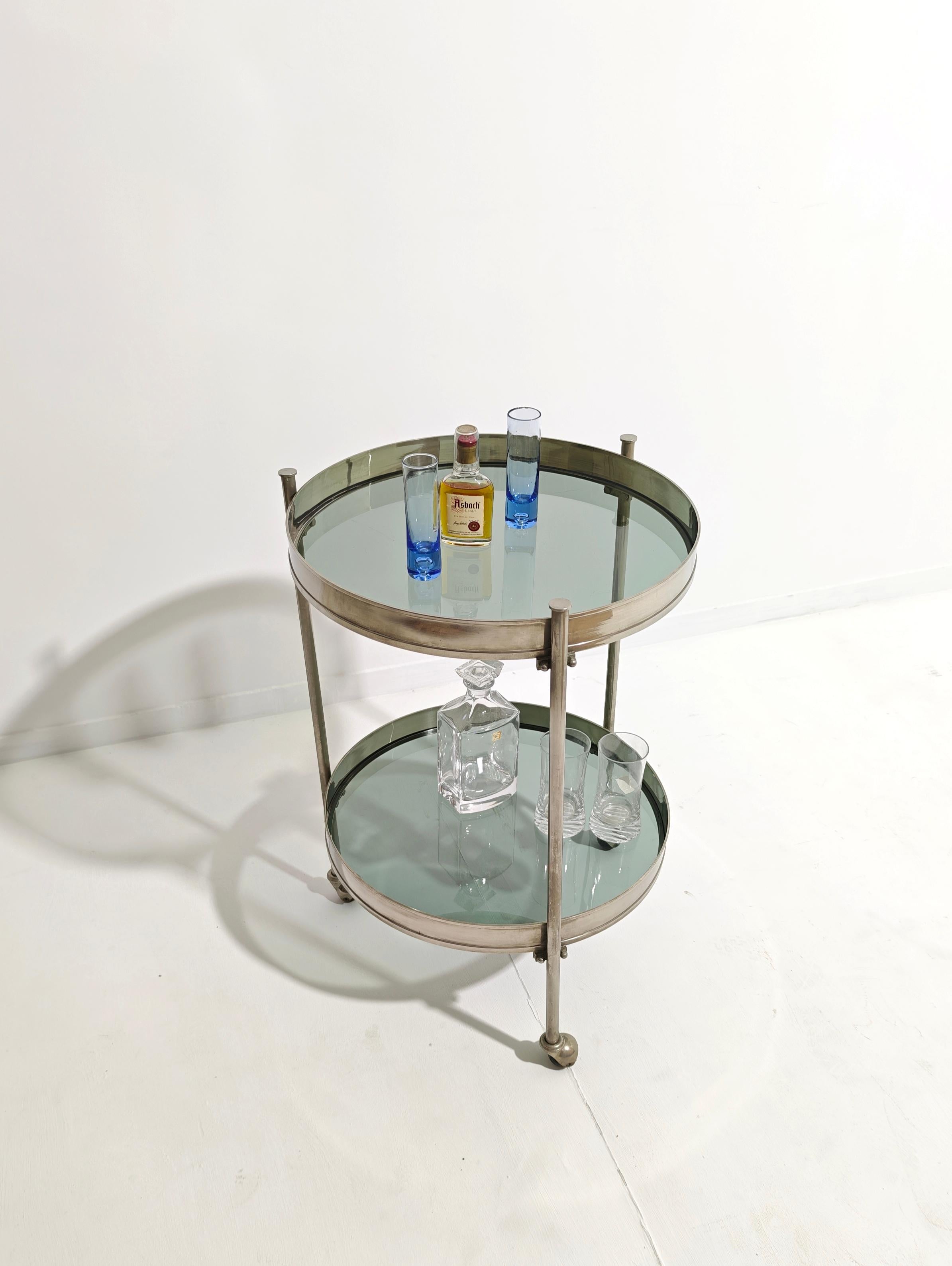 Seltener zweistöckiger runder Barwagen aus gebürstetem, vernickeltem Messing und Rauchglas. Hergestellt in Italien in den 1970er Jahren von Binox. Lässt sich leicht als Servierwagen für Empfänge umfunktionieren. Drei Beine tragen die obere und
