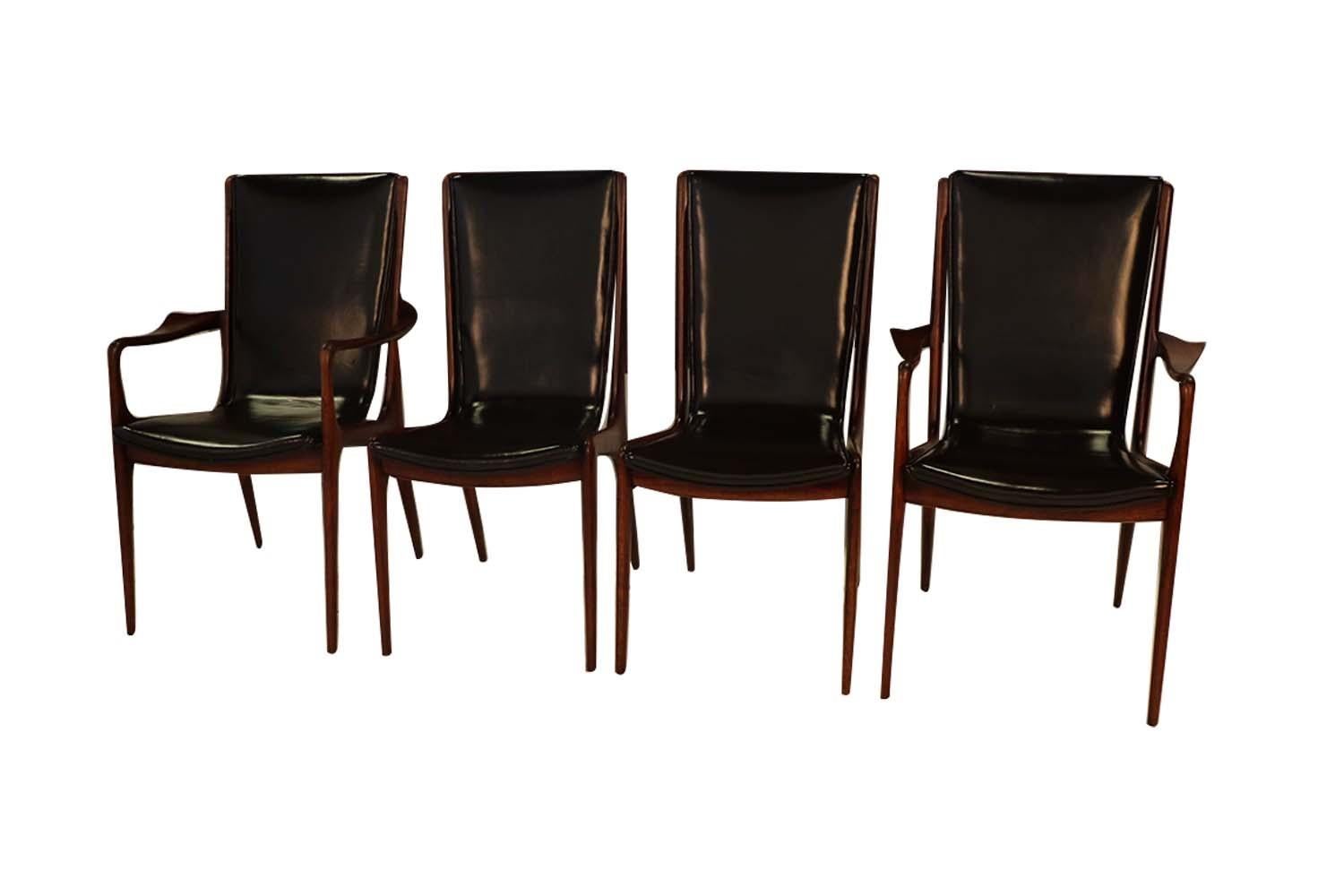 A beautiful rare set of four American walnut, Vladimir Kagan sculpted sling dining chairs, in black leather. This spectacular set of American walnut dining chairs consists of two VK 101 side chairs, and two VK 101A arm chairs. Signed with branded