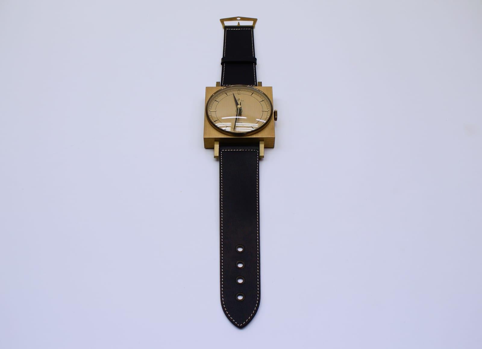 Midcentury wall clock in the form of a wristwatch in leather and brass, Germany

Made in Germany by Meister Anker.

Electric, battery operated clock.