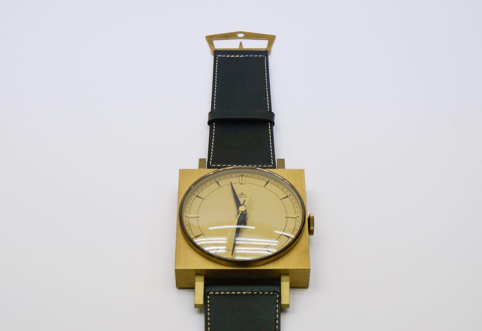Mid-Century Modern Horloge murale du milieu du siècle dernier en forme de montre-bracelet en cuir et laiton, Allemagne en vente
