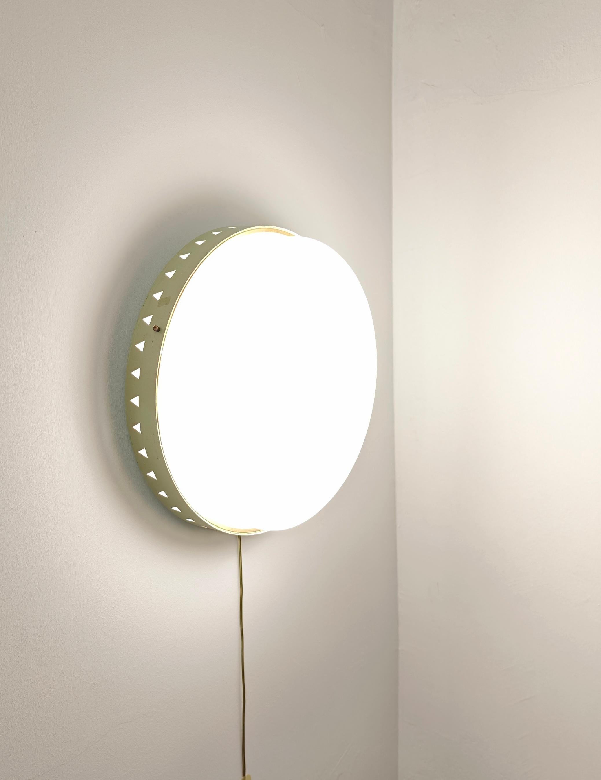 Applique ou plafonnier, fabriqué en Italie dans les années 50/60. La lampe a une structure en métal émaillé de couleur aigue-marine avec des motifs géométriques, où un cercle en laiton et un diffuseur circulaire en plexiglas s'emboîtent et sont