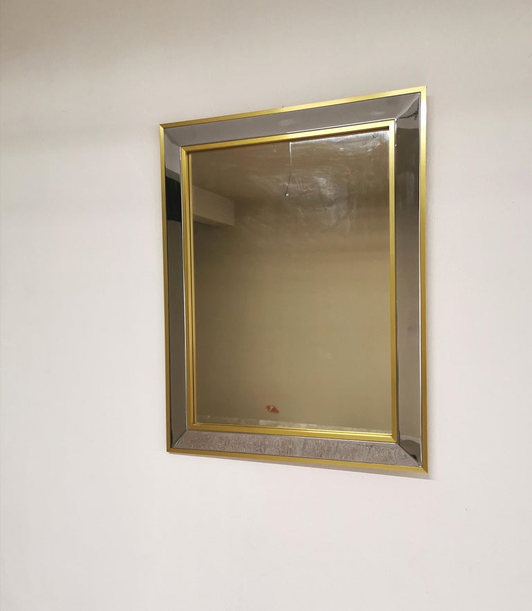 Wall mirror attributed to Willy Rizzo in chromed metal with embossed corners and gilt aluminum border. Italian product of the 1970s.