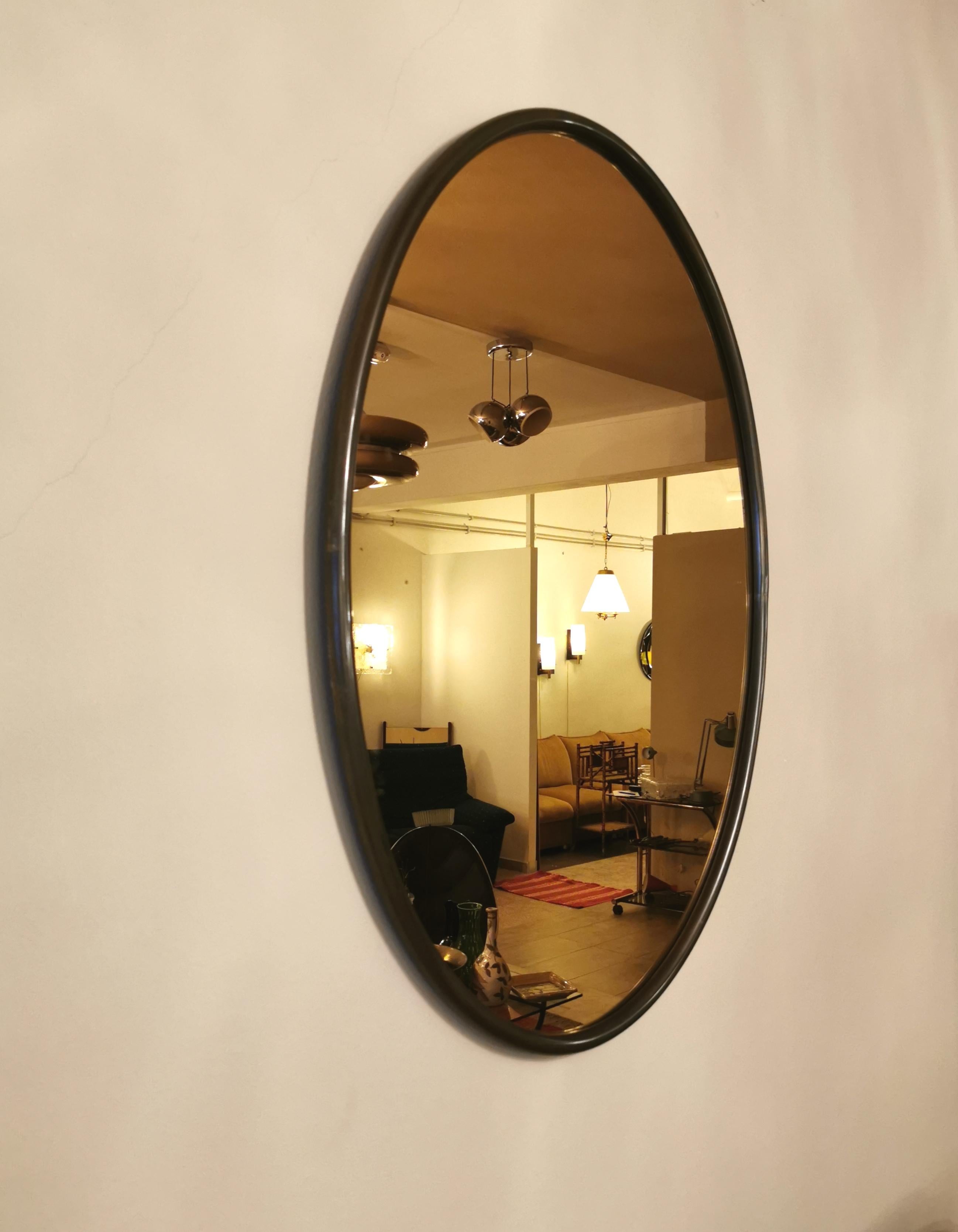 Oval shaped wall mirror with tubular brass frame. Thanks to its caramel-colored mirror, it makes it elegant and adaptable to any environment. Made in Italy in the 1960s. Having two rear hooks it is possible to position the mirror both vertically and