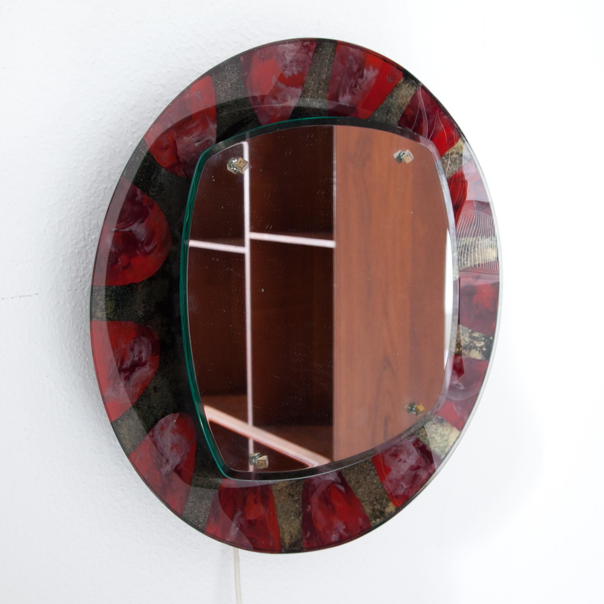 Illuminated wall mirror with a gold-red glass frame by Santambrogio & De Berti. Labeled on the back. For the electrification we assume no liability and no warranty.