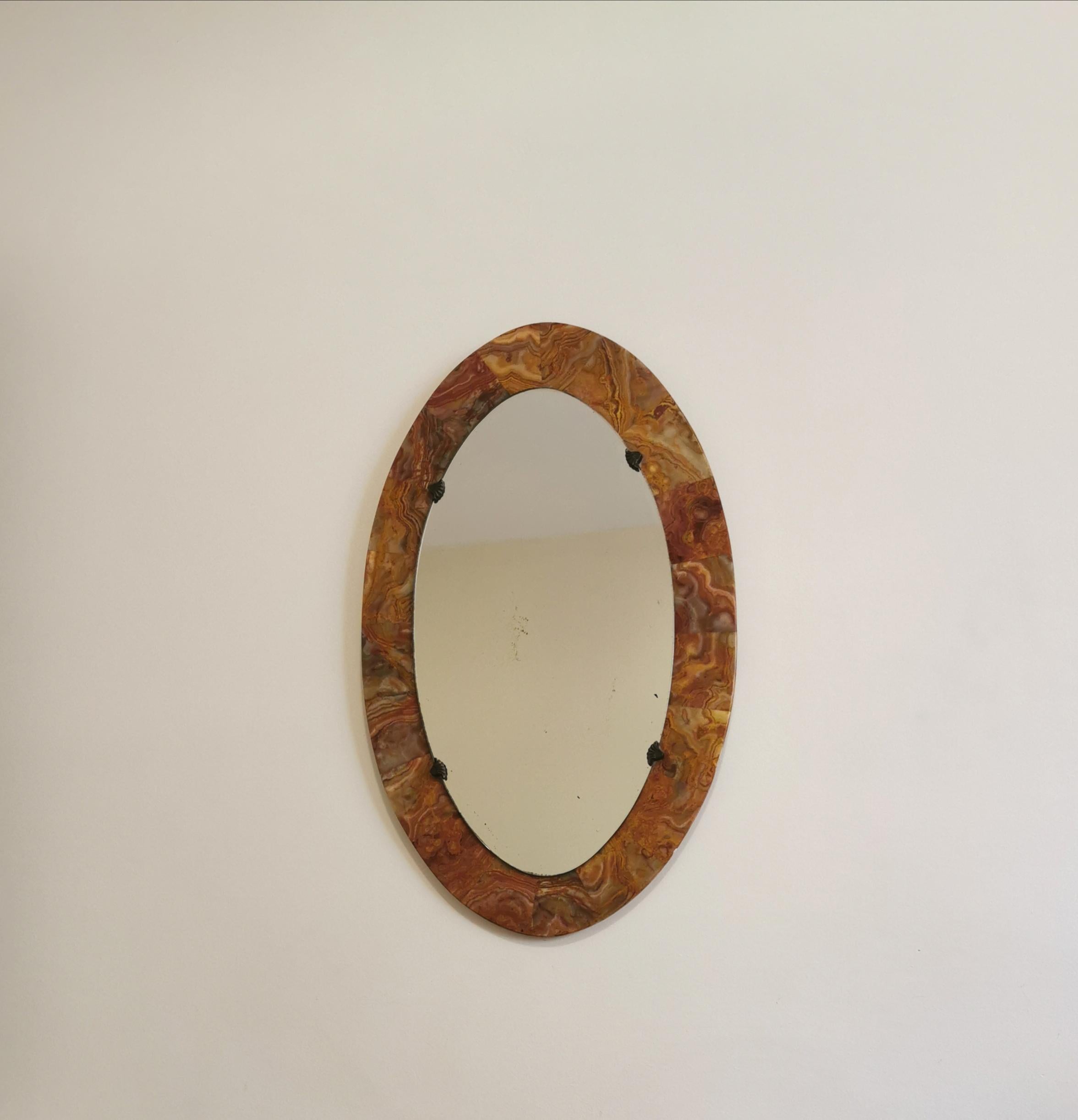 Particular wall mirror with red marble structure of round shape, Italian production of the 1950s.