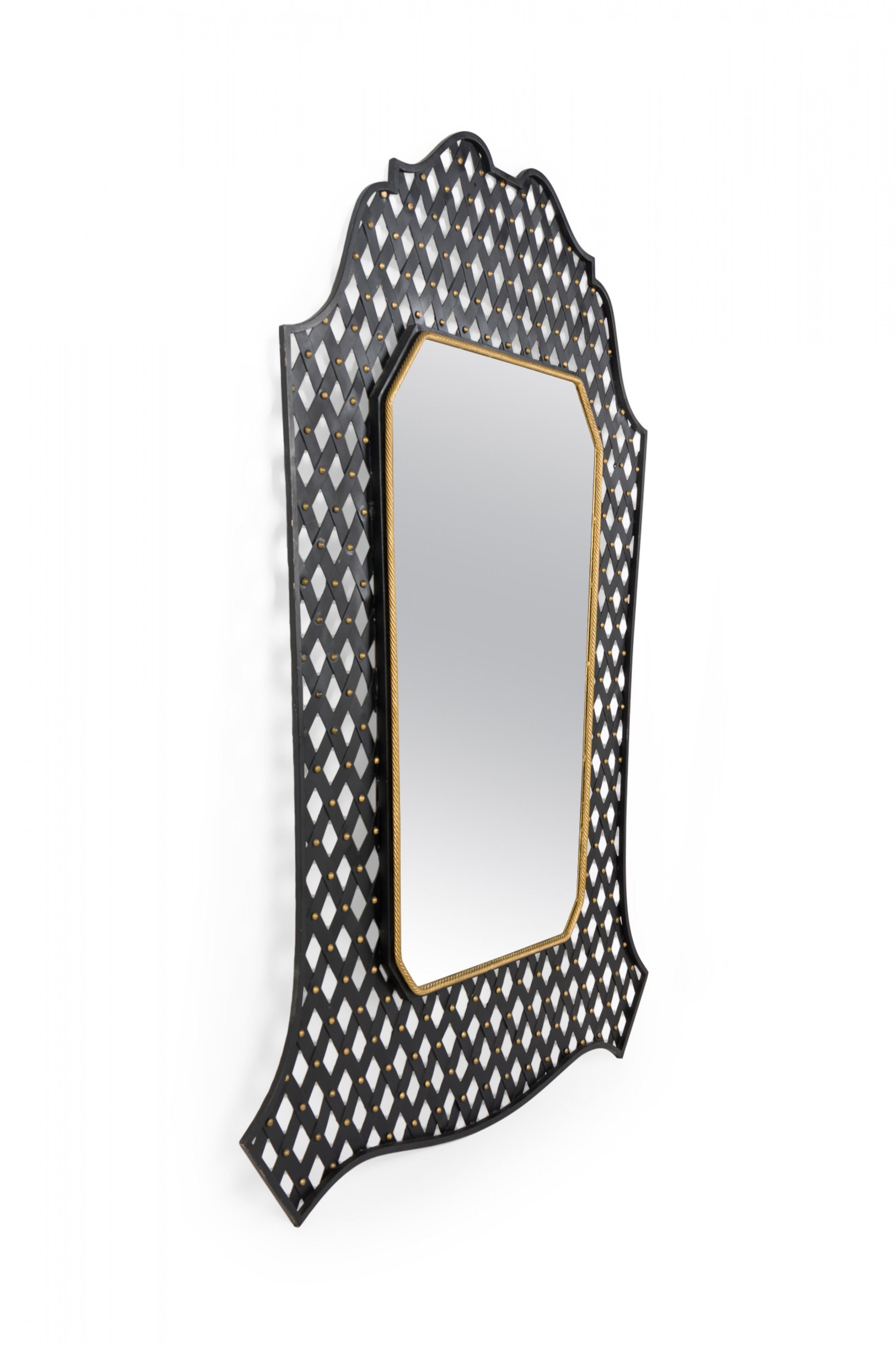Mid-Century American wall mirror in rectangular form with a shaped pediment encased in a black metal lattice frame with applied gilt metal faux rope border surrounding the glass.
 