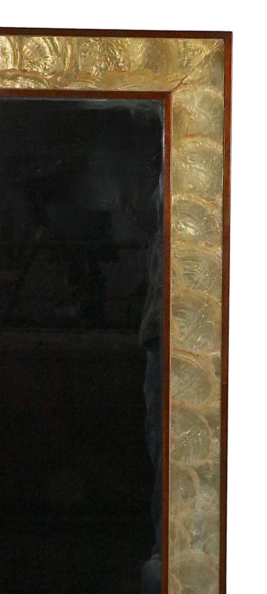 Schicker rechteckiger Wandspiegel mit einem eleganten Rahmen aus Walnussholz, der das Innere mit goldfarbenen Kapiz-Muscheln umgibt.
Zurzeit ist der Spiegel so konfiguriert, dass er vertikal hängt, aber er kann auch leicht horizontal aufgehängt