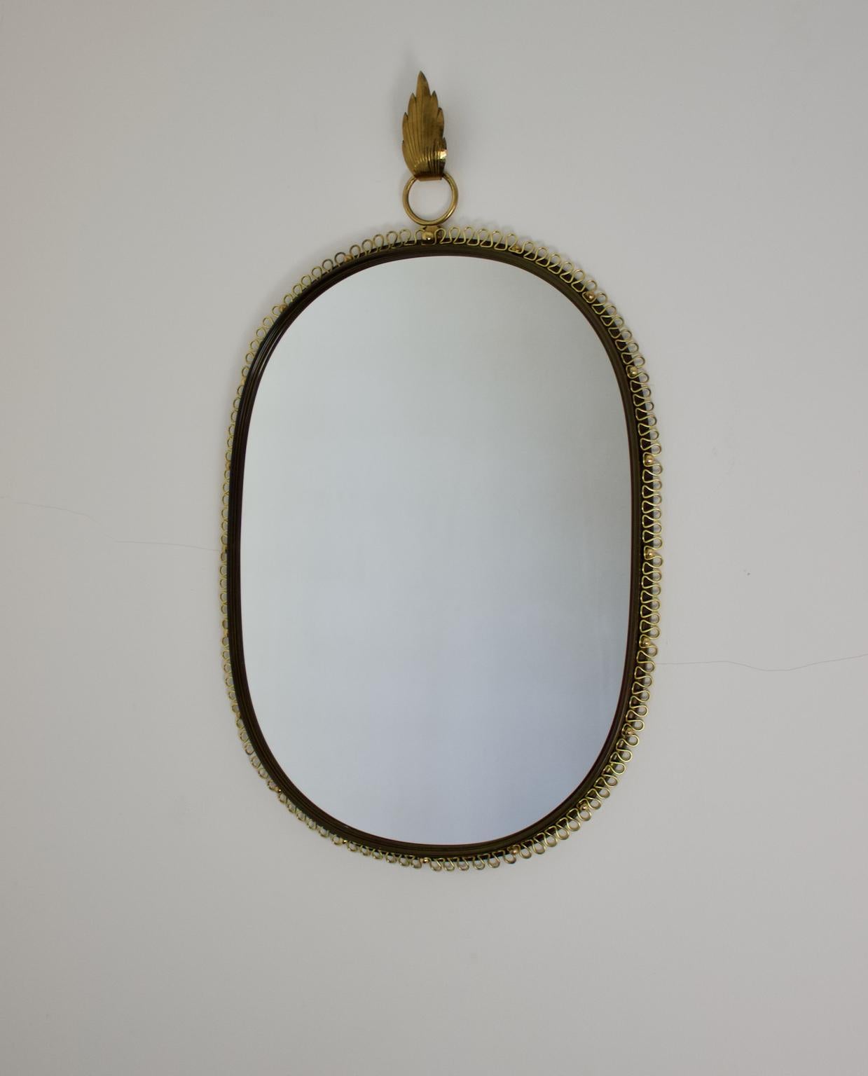 Mid-20th century wall-mounted mirror with brass loop frame, by Josef Frank for Svenkst Tenn, Sweden.

A very attractive mirror, with decorative brass loop and ball frame, and complete with the original leaf-shaped hanging hook in nicely hammered